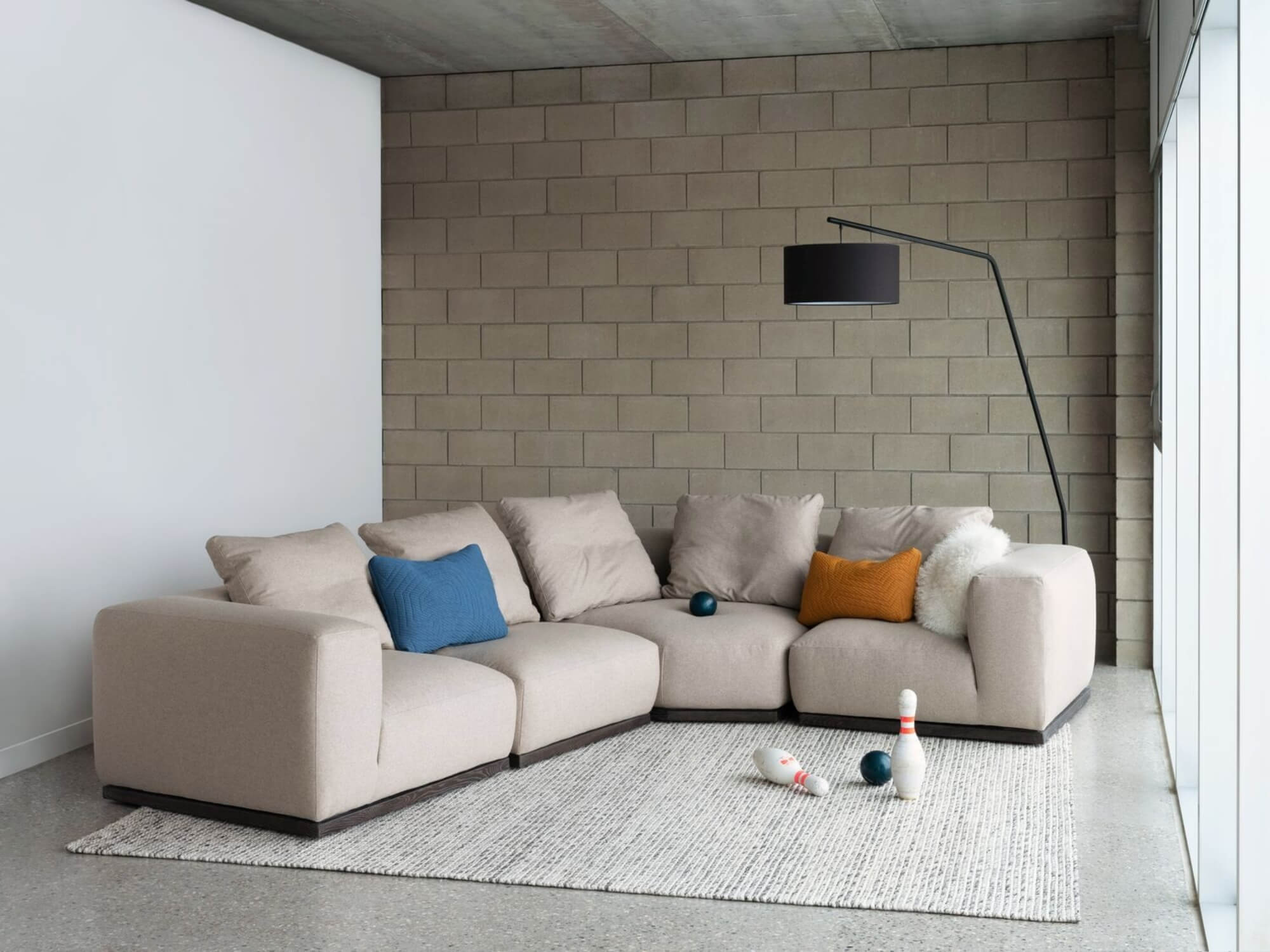 Area rug under beige modular sofa in industrial space