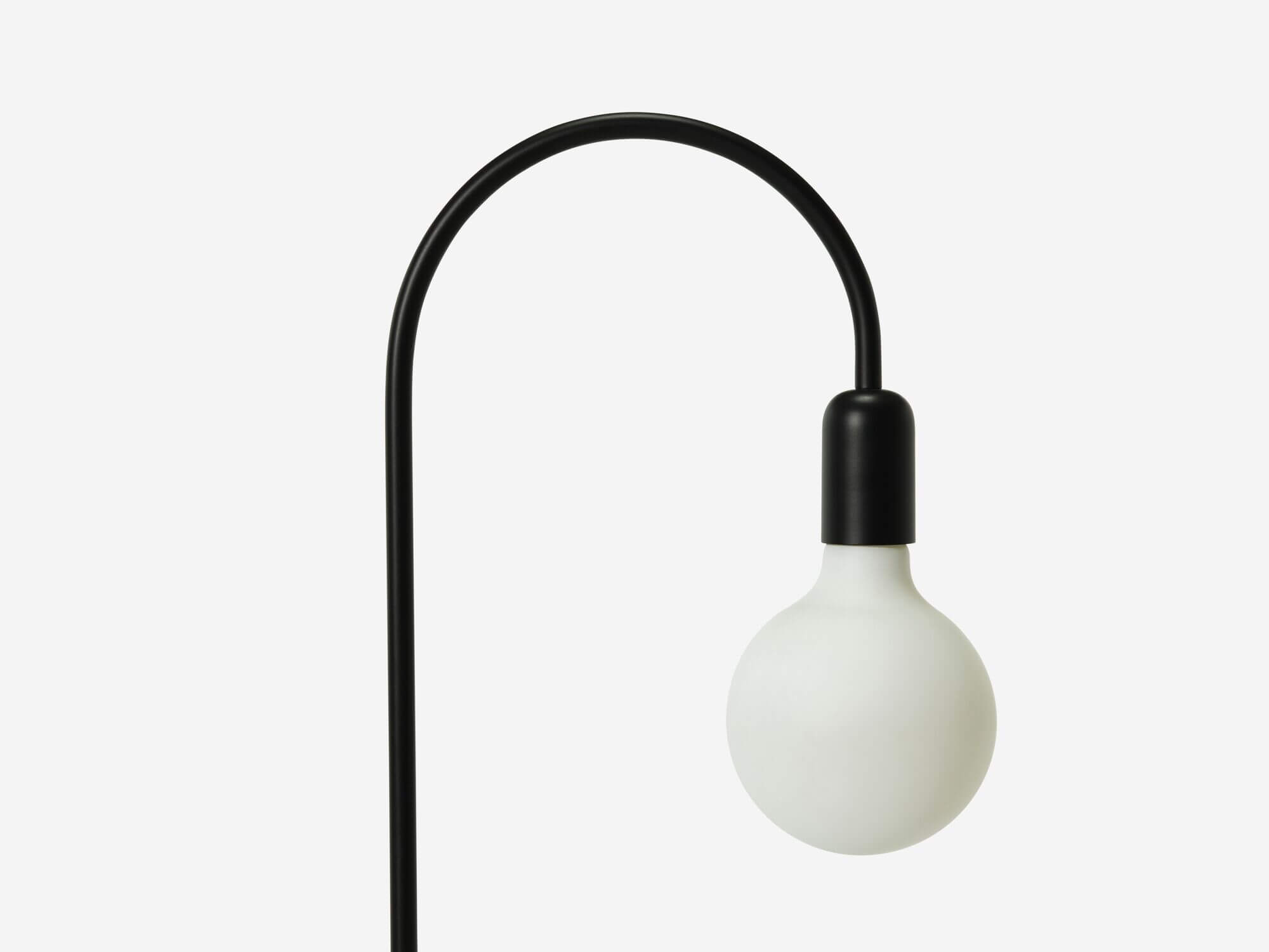 Detail bulb view of black arched floor lamp
