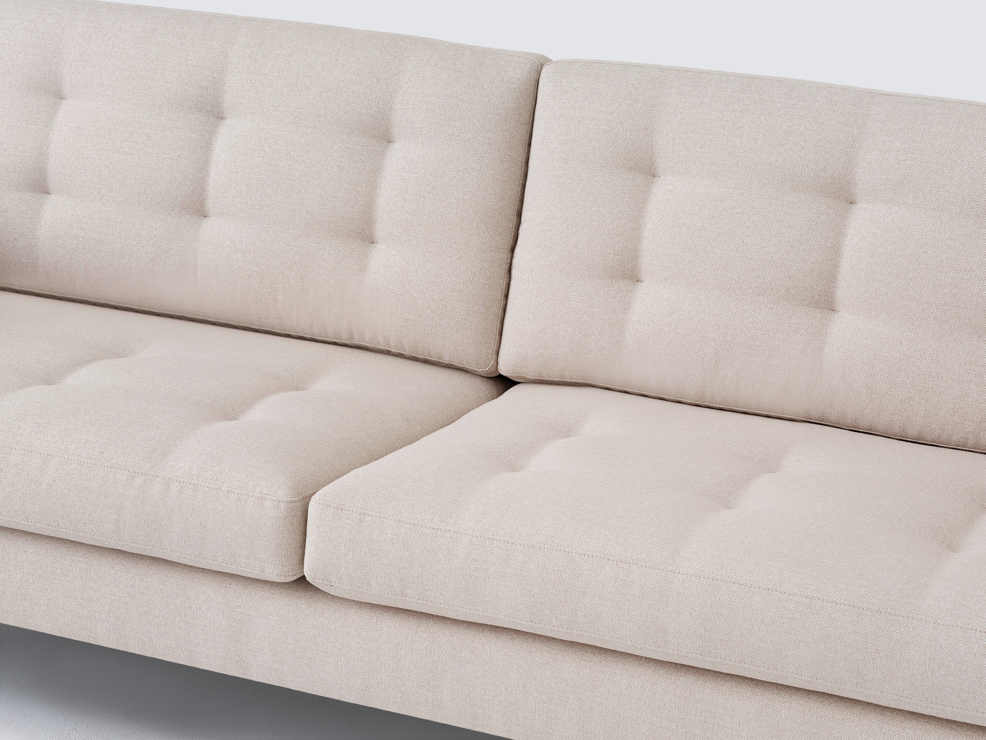 Detail view of the Joan long modern sofa upholstered in beige fabric