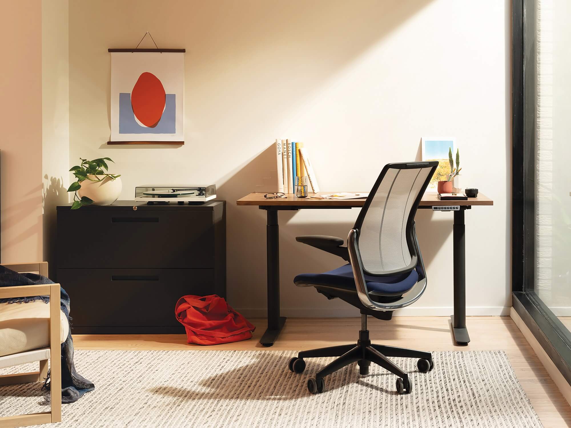 Walnut top sit stand desk with ergonomic chair in home office