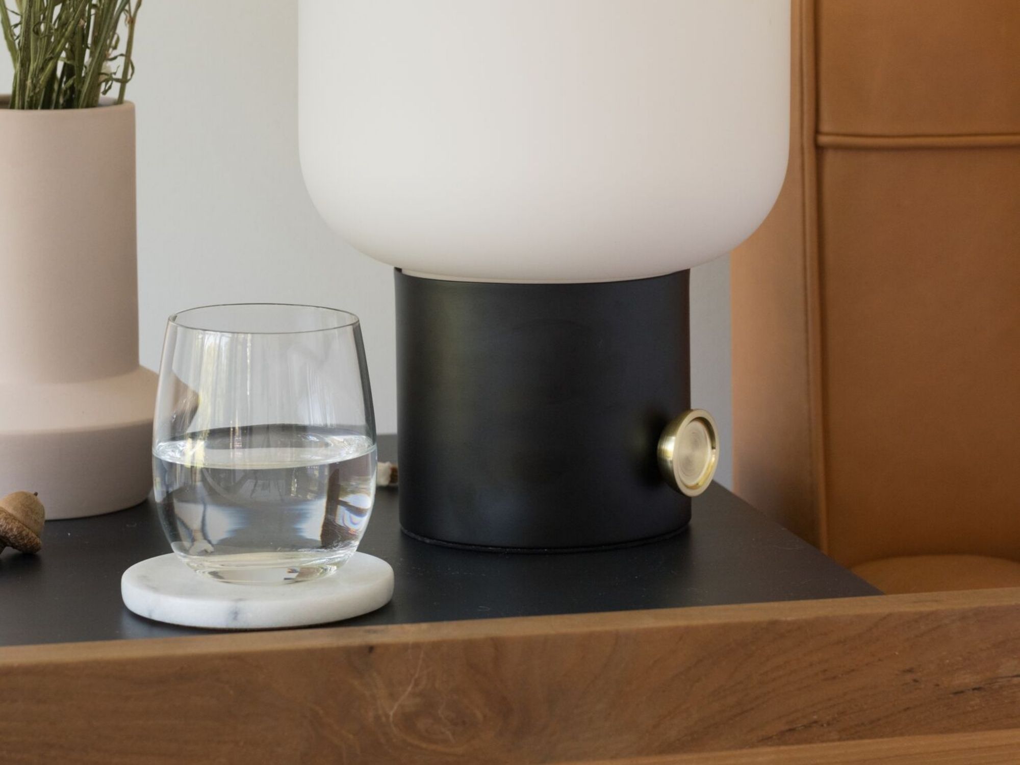 Clear glass tumbler on teak bedside table