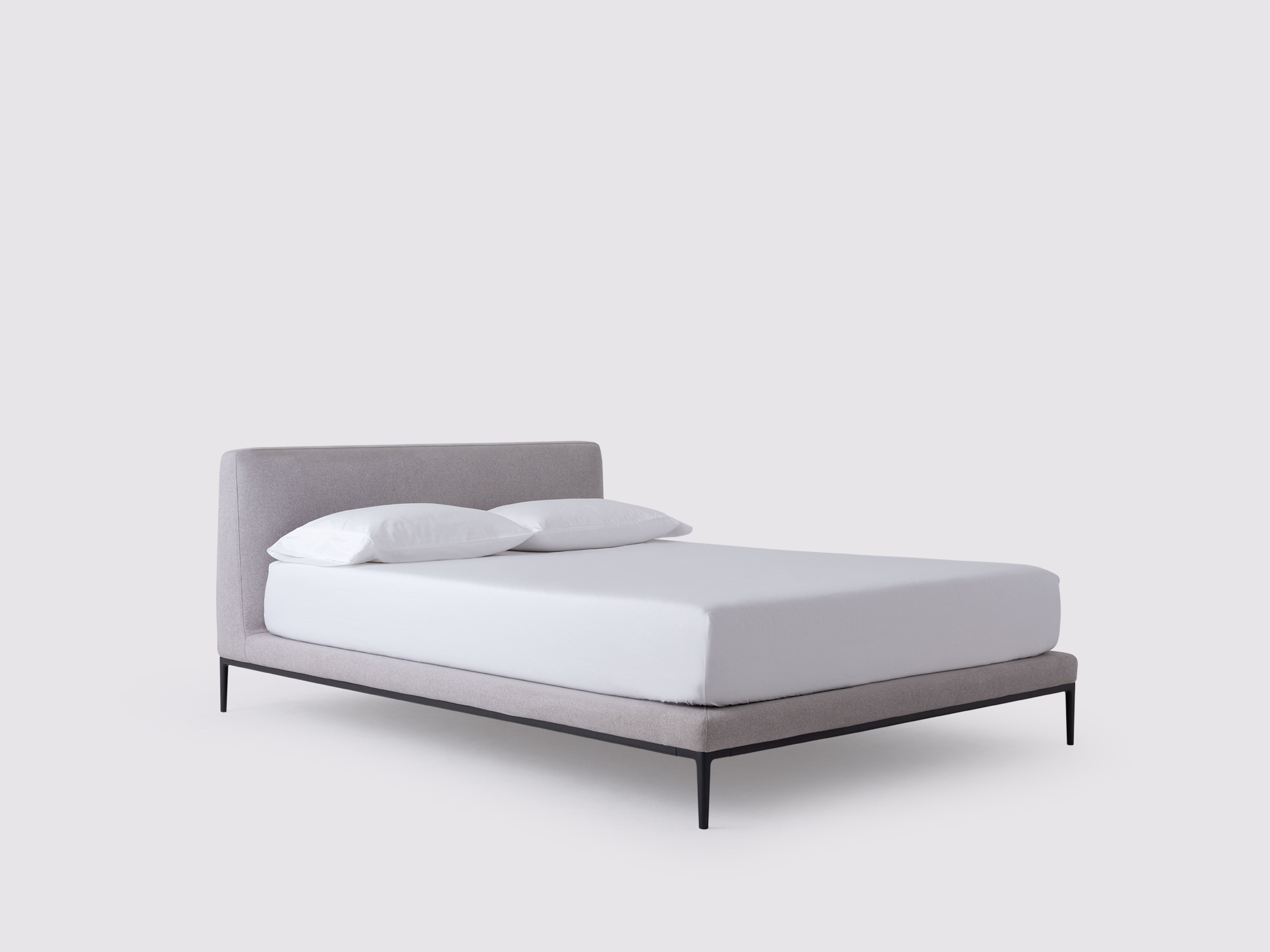 Angled view of the Oma modern upholstered bed in grey fabric