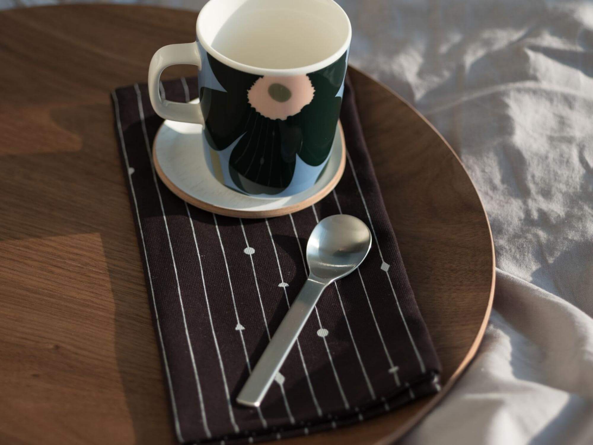 Walnut serving tray with spoon, coffee mug, and napkin on it