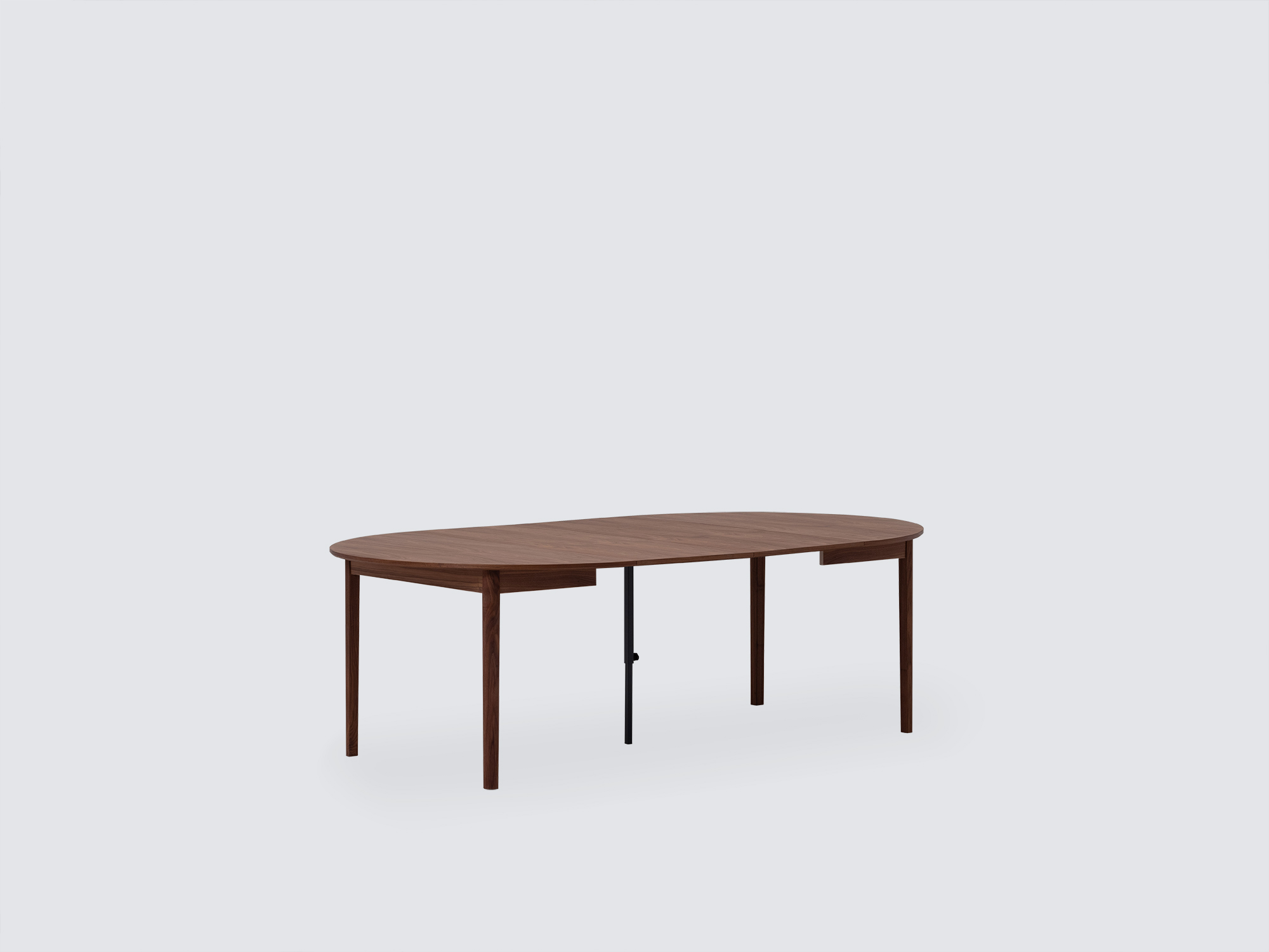 Angled view of the small expanded Ease Expandable Dining Table in walnut