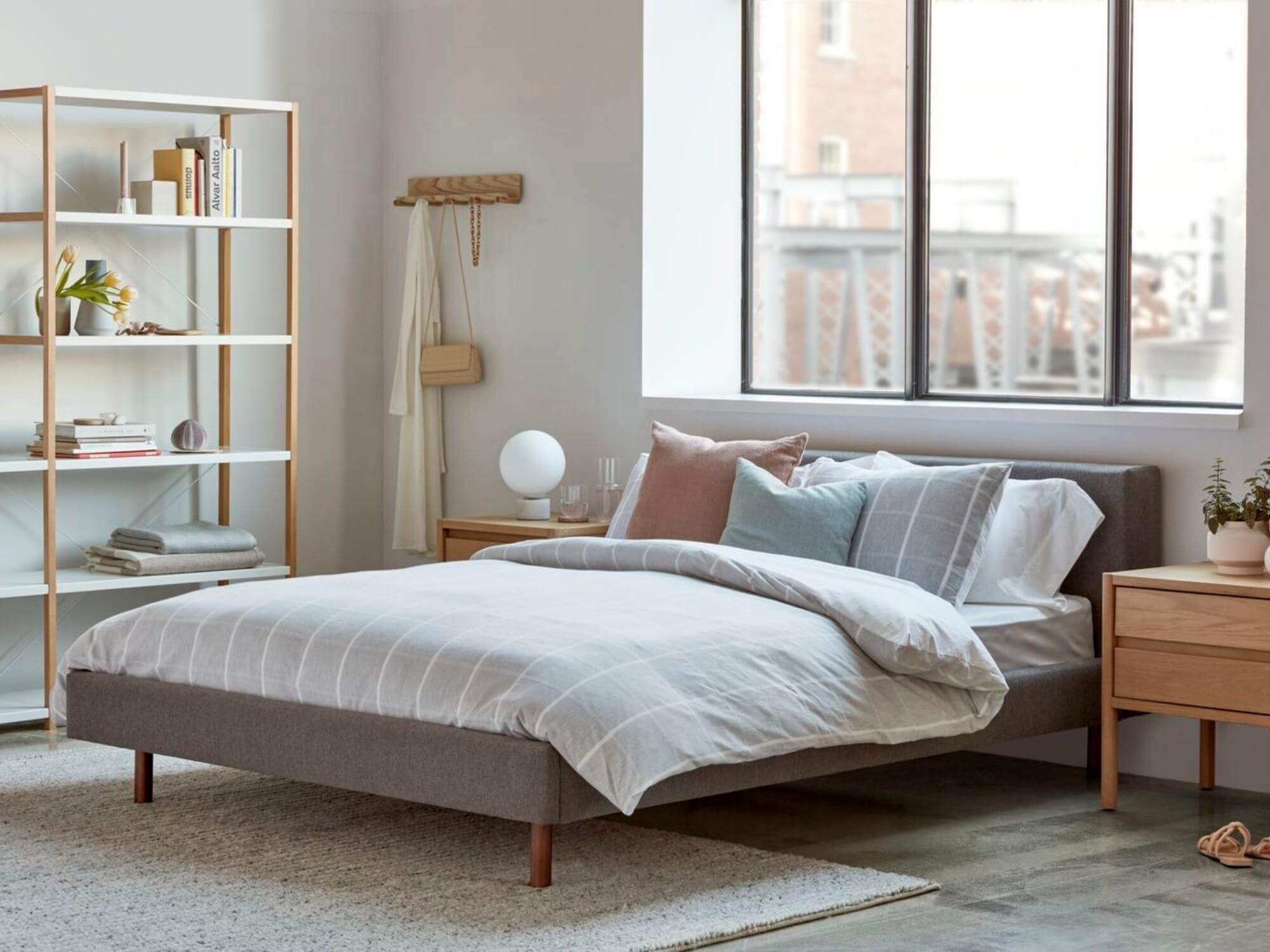 Braided wool rug under upholstered bed frame in bedroom
