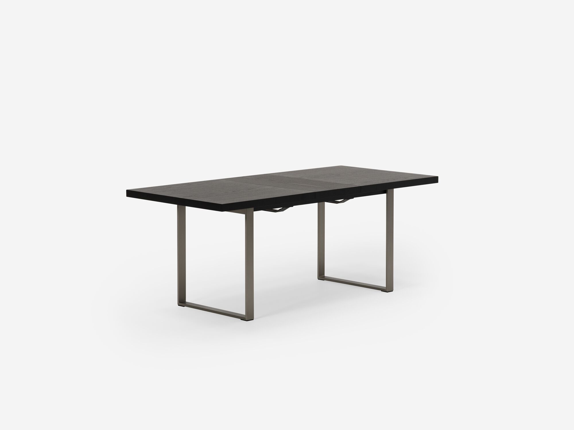 Expandable dining table with stainless steel legs, walnut top and one leaf corner view