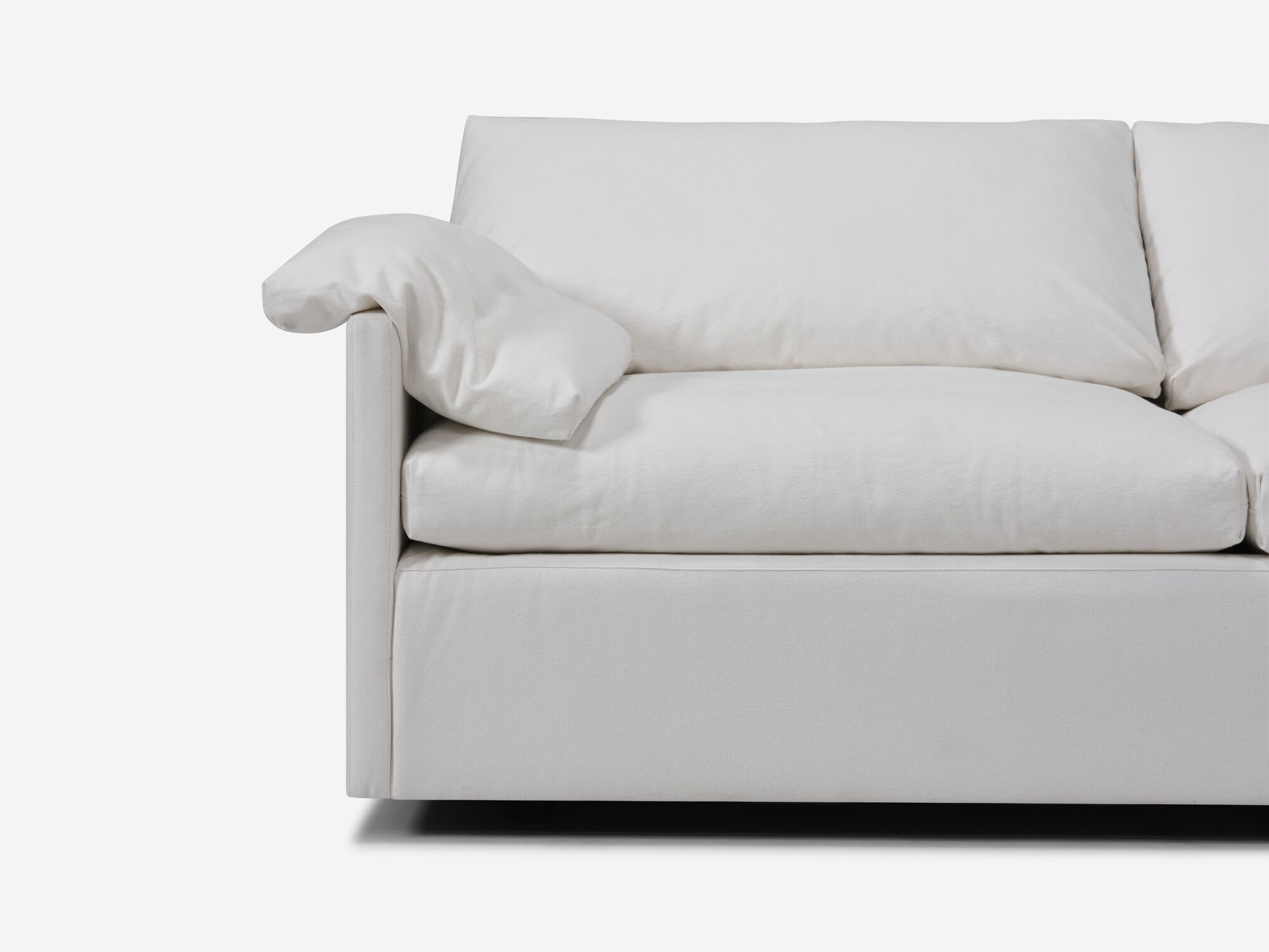 Seat view of white sectional sofa with narrow arms, pillow and right hand chaise