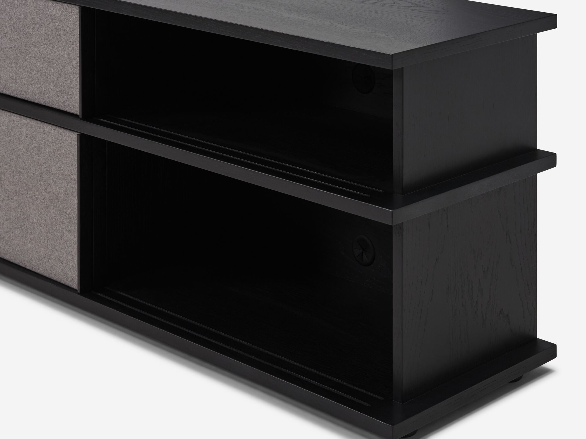 Detail view of tall black oak media unit with fabric panels with open storage