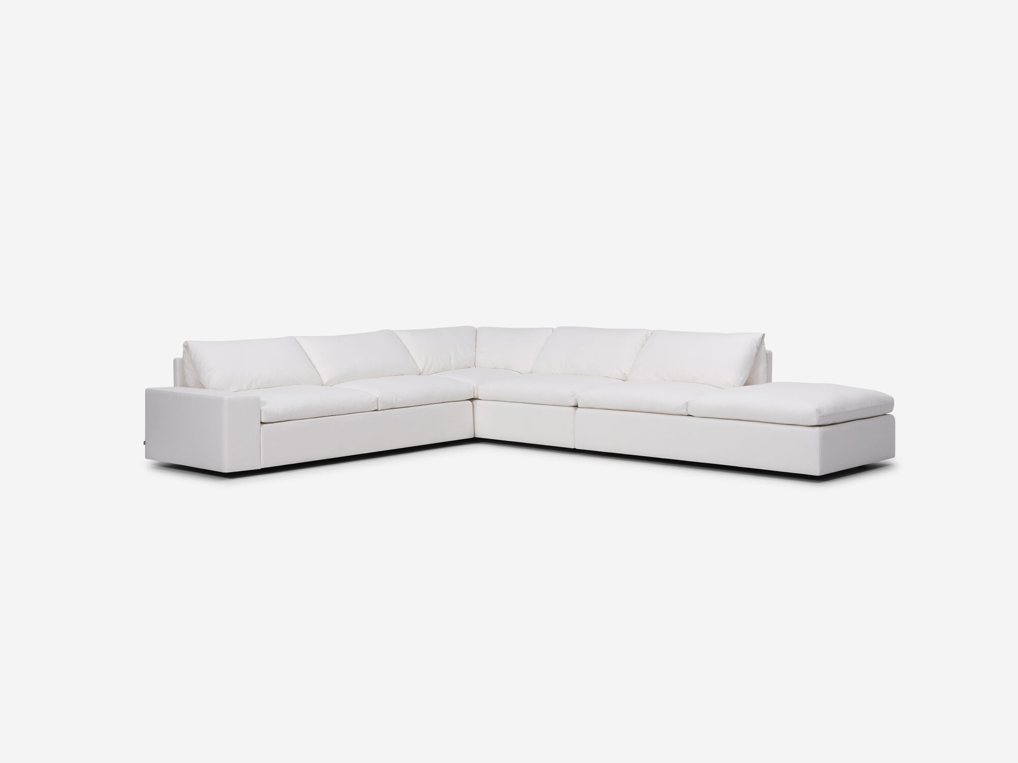Left angle view of white sectional sofa with right hand chaise and wide arms