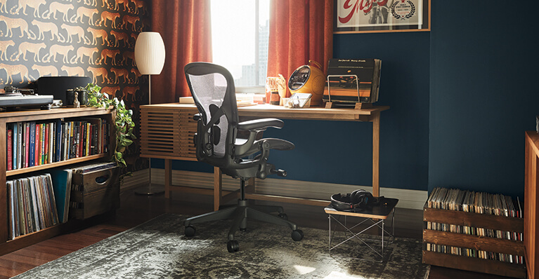 Chaise Aeron en graphite Herman Miller est présentée dans un bureau à domicile. Lien vers la catégorie de vente Herman Miller