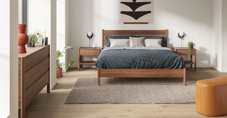 queen size walnut bed is shown in a bedroom with matching nightstands and dressers