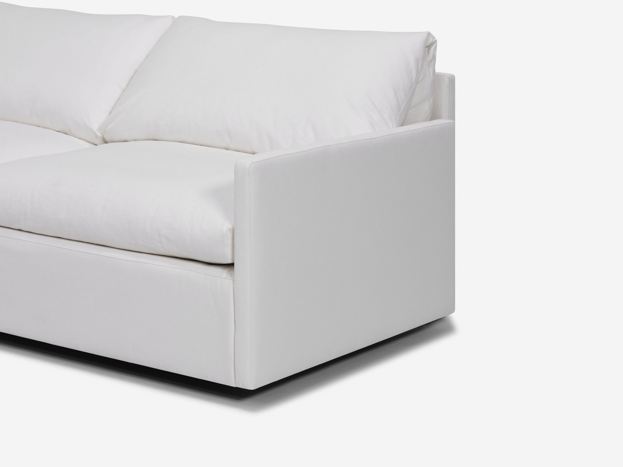 Angle detail view of white sectional sofa with narrow arms