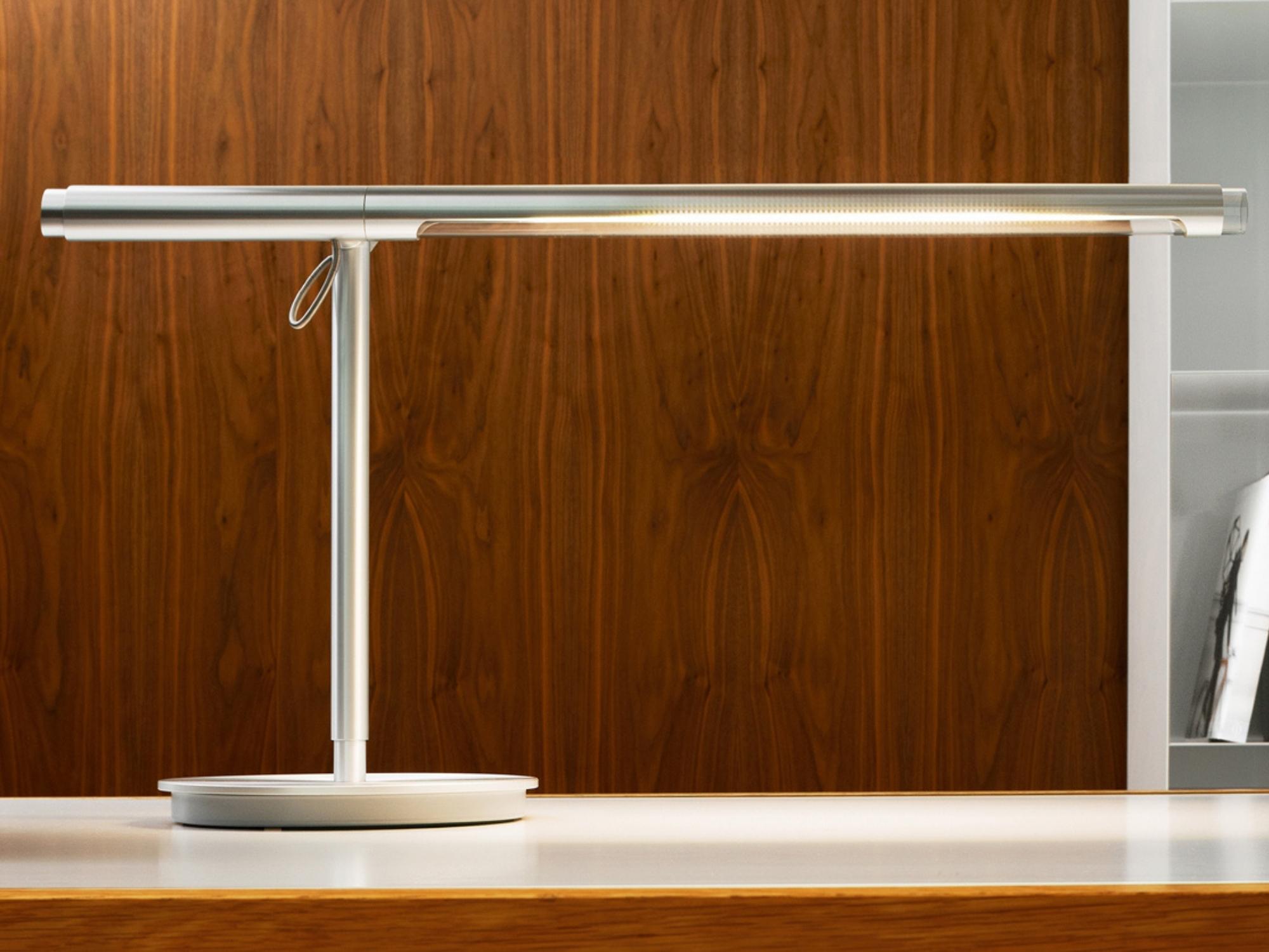 Side view of the Brazo Table lamp in silver over modern workspace 