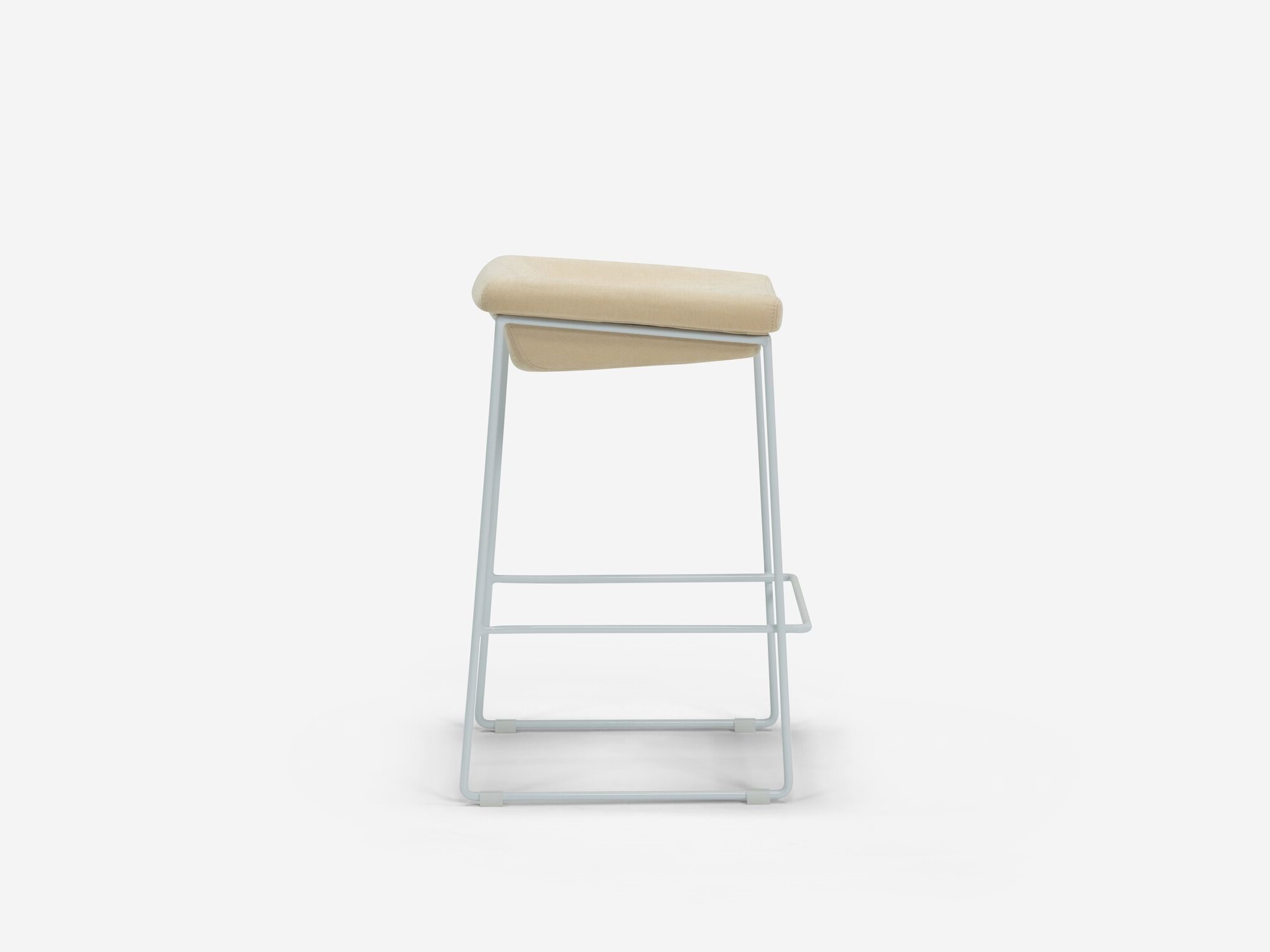 Side view of counter stool with beige seat and white legs