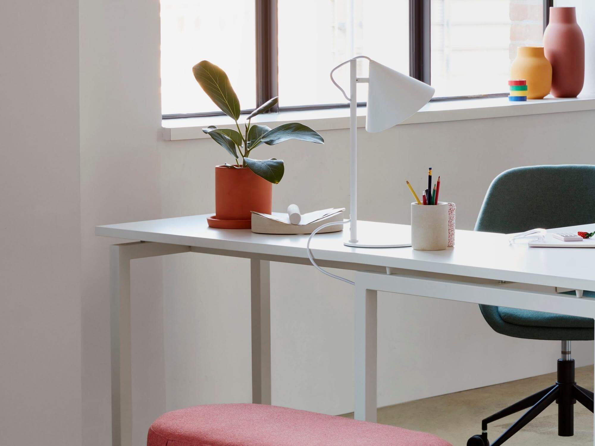 White paper holder beside table lamp on the white working table