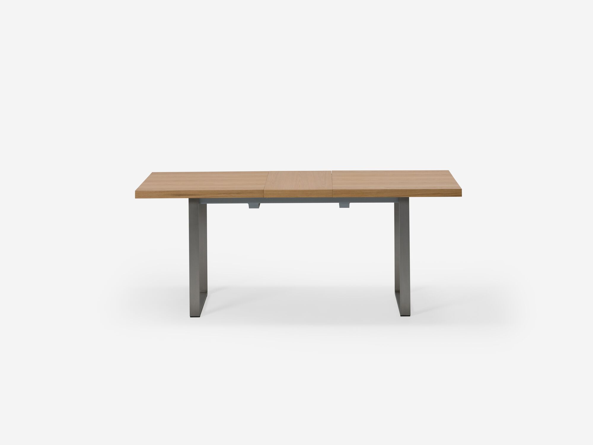 Side view of expandable dining table with stainless steel legs and oak top with one leaf