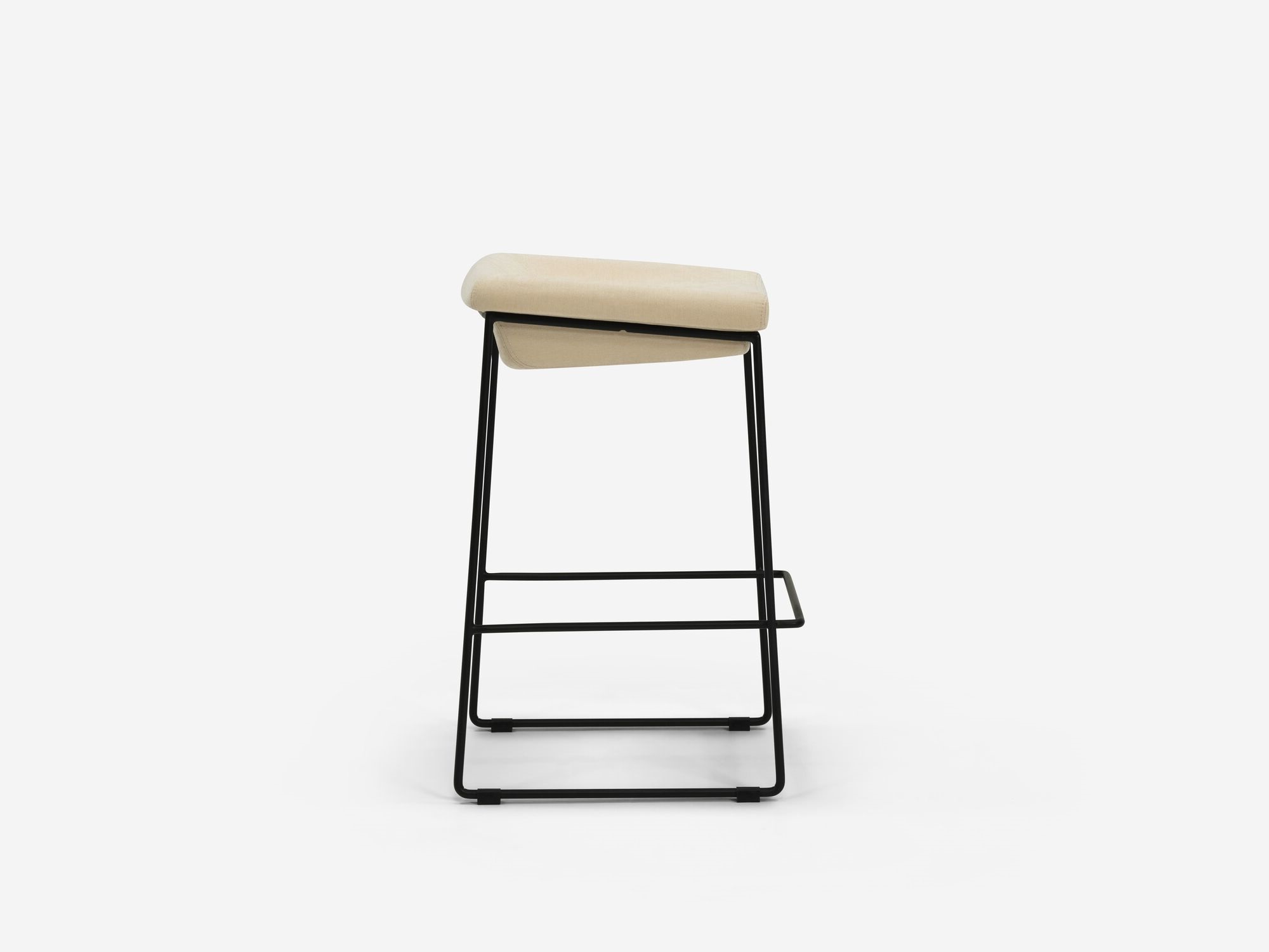 Side view of counter stool with beige seat and black legs