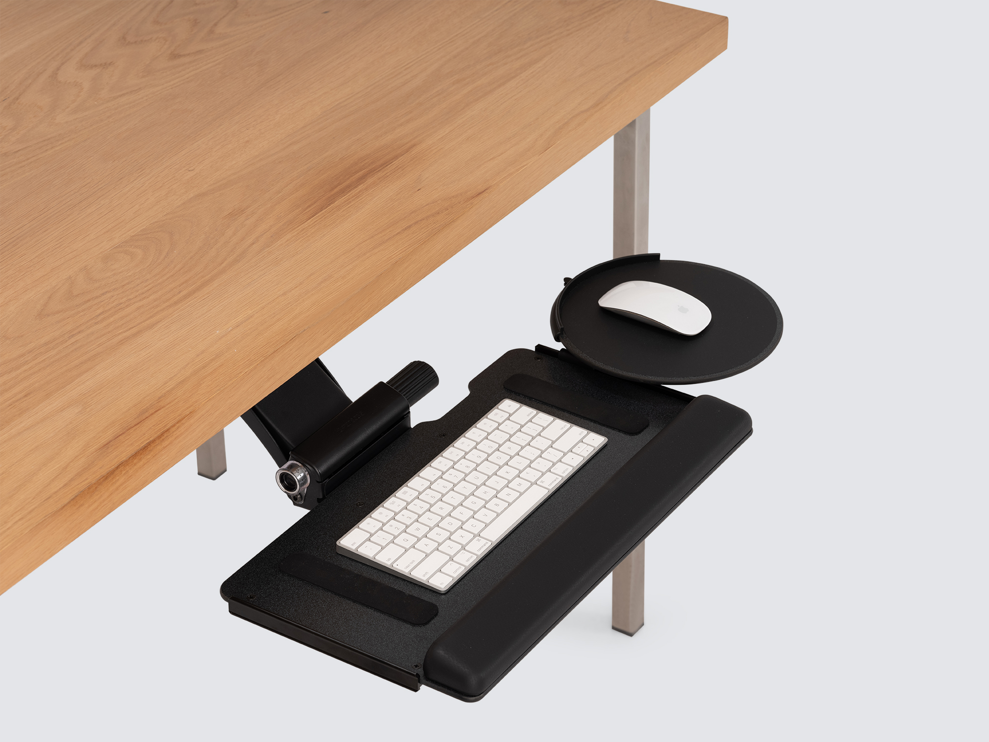 The Humanscale Keyboard Tray in black pulled out from an oak desk