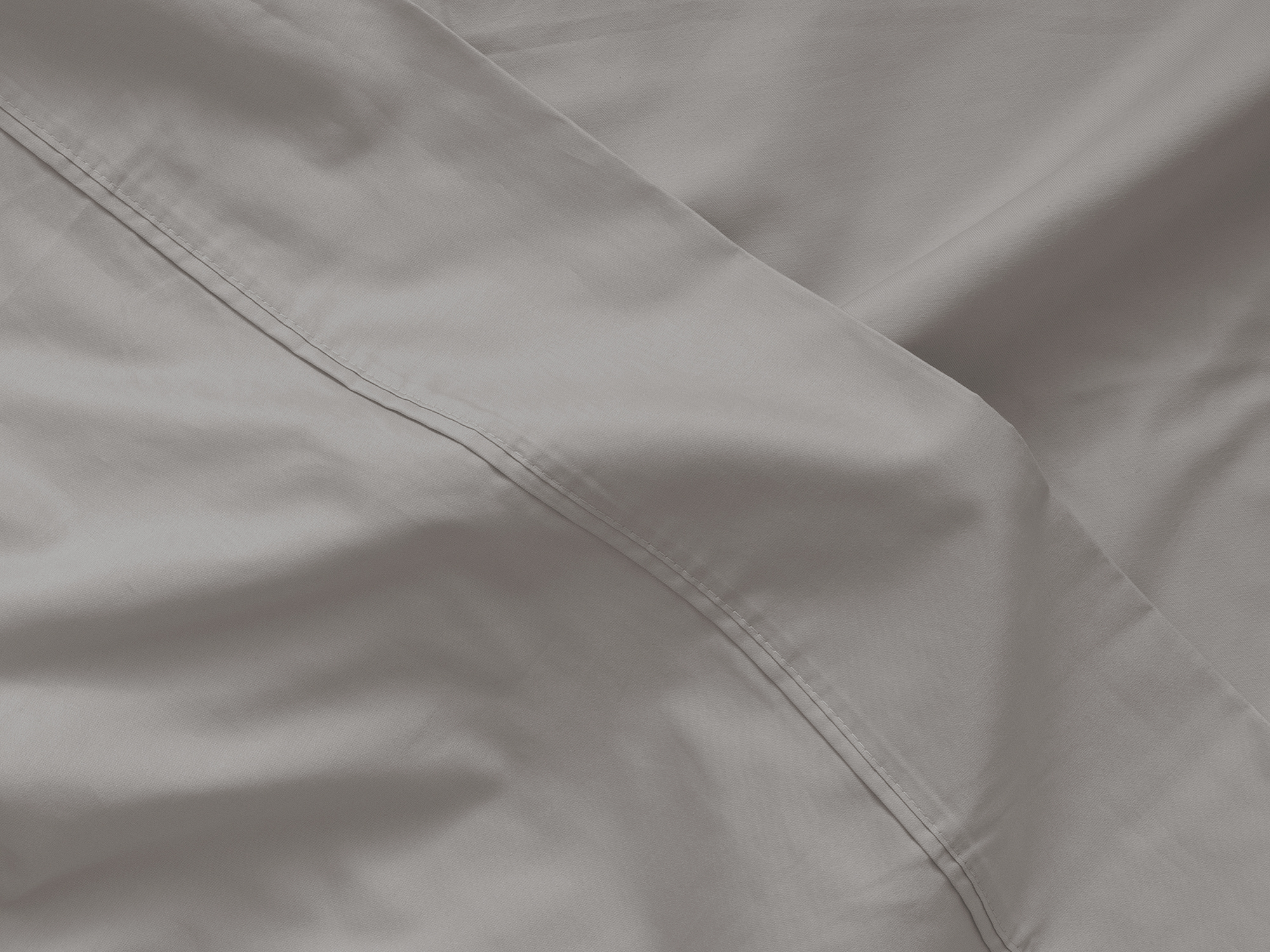 Detail view of top fold of organic cotton bed sheets in grey