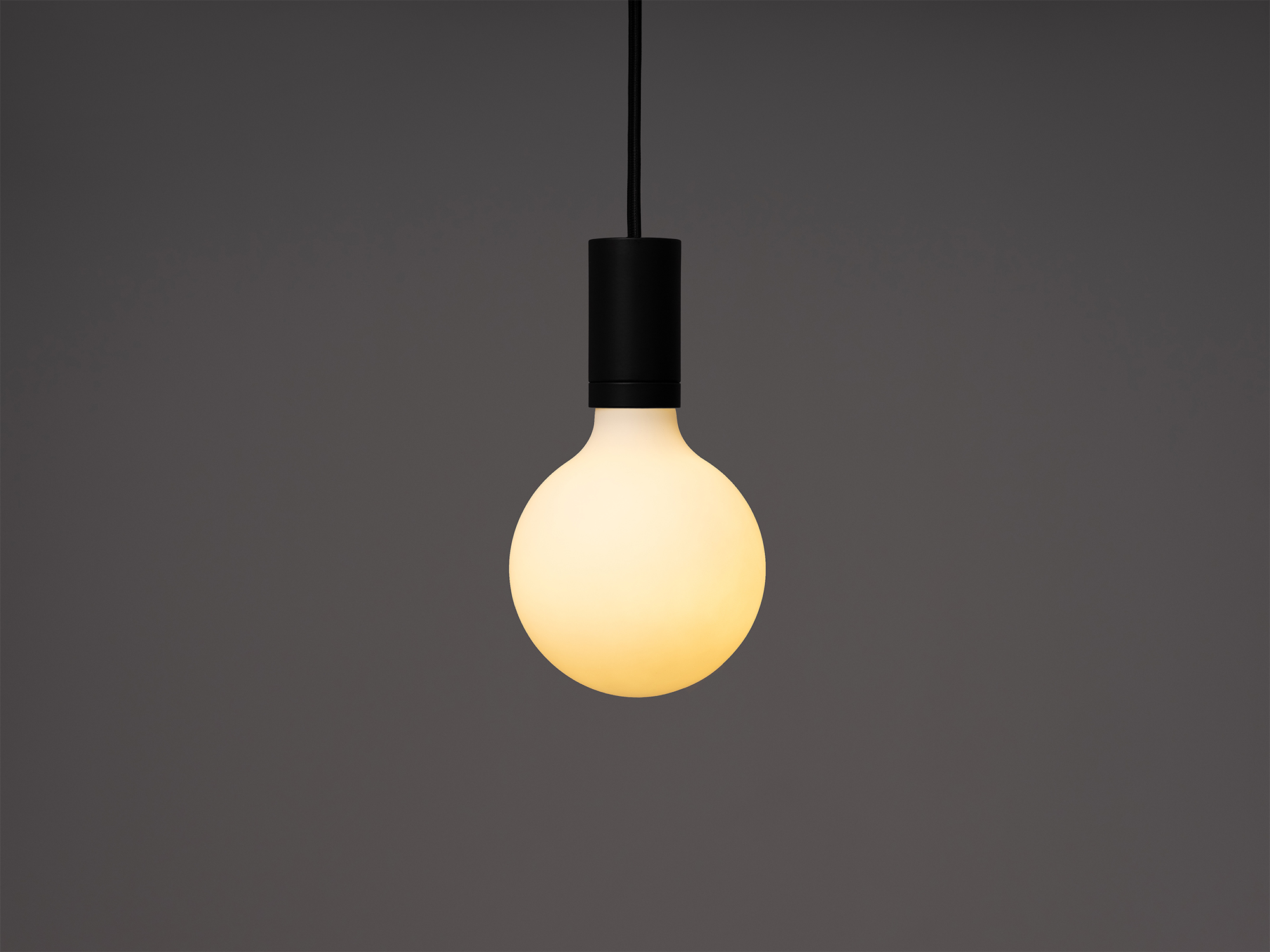 Medium round matte white LED light bulb in a pendant