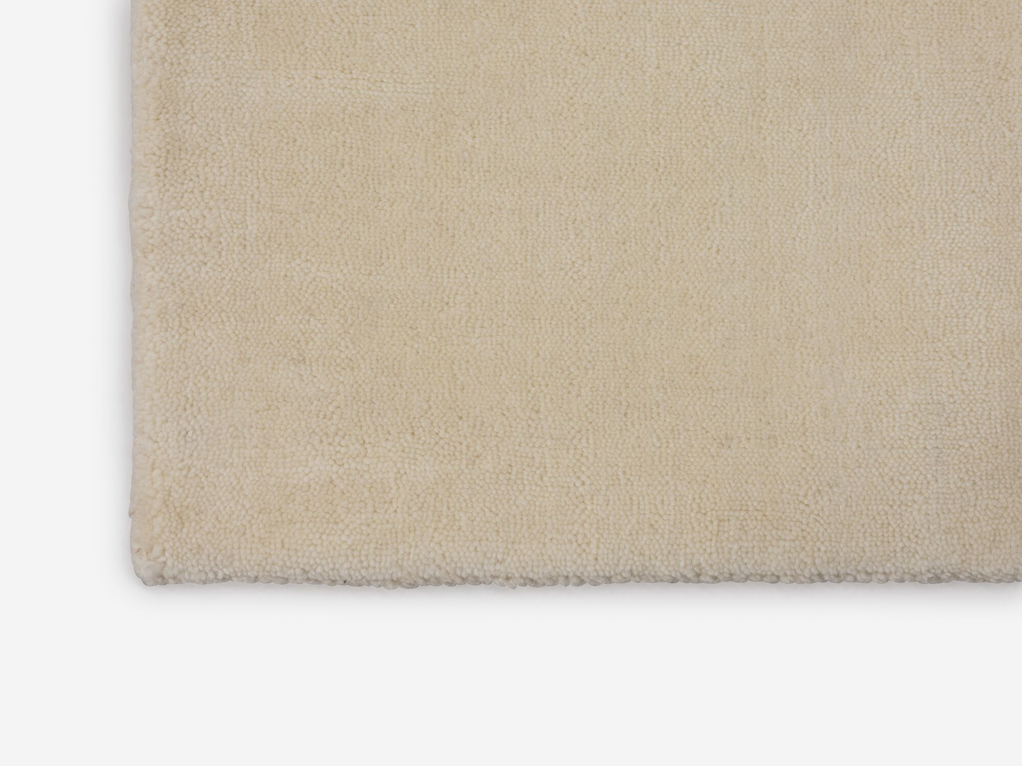 Corner view of large durable cream area rug