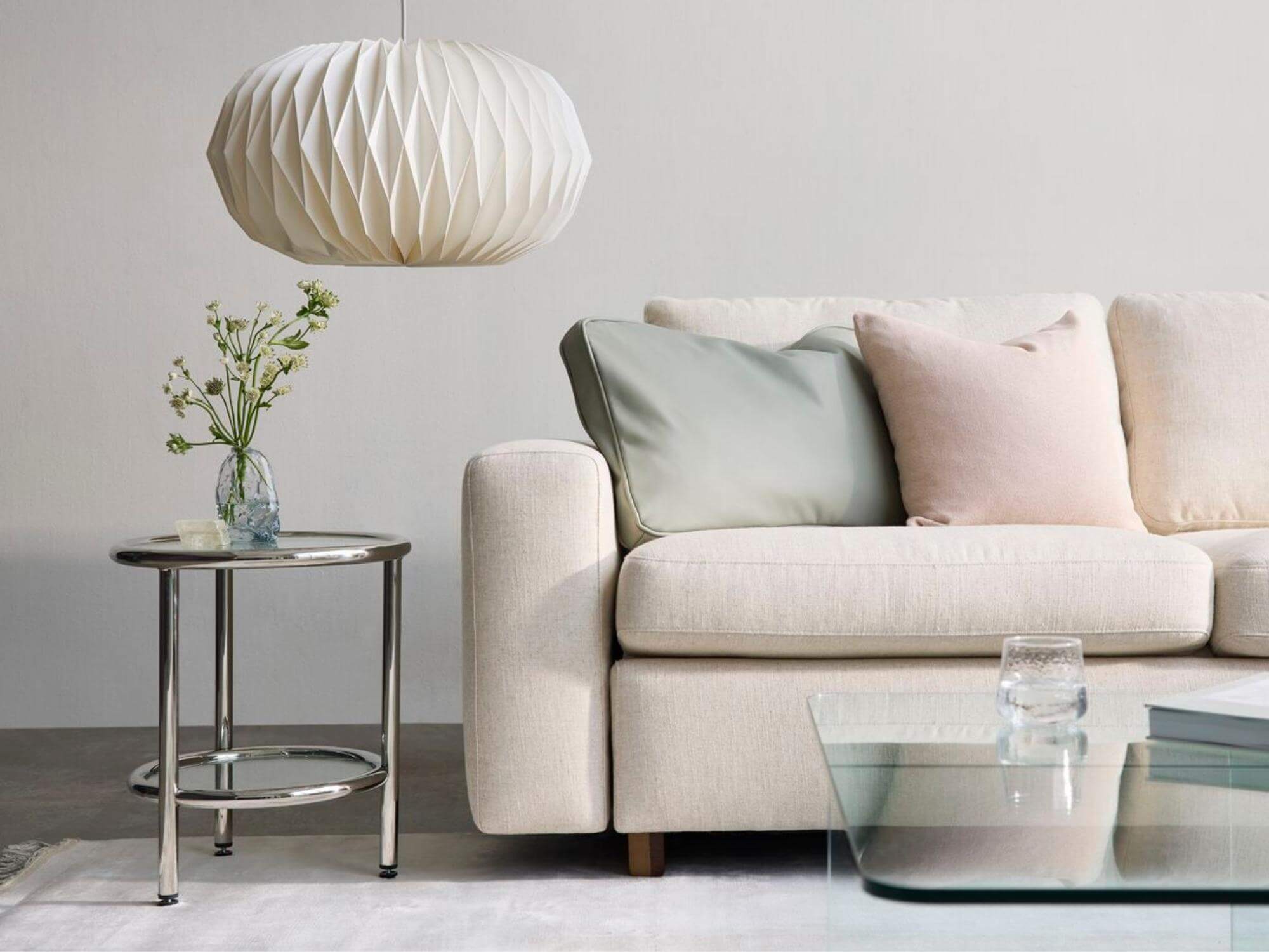 Steel end table with beige sofa and paper pendant lamp
