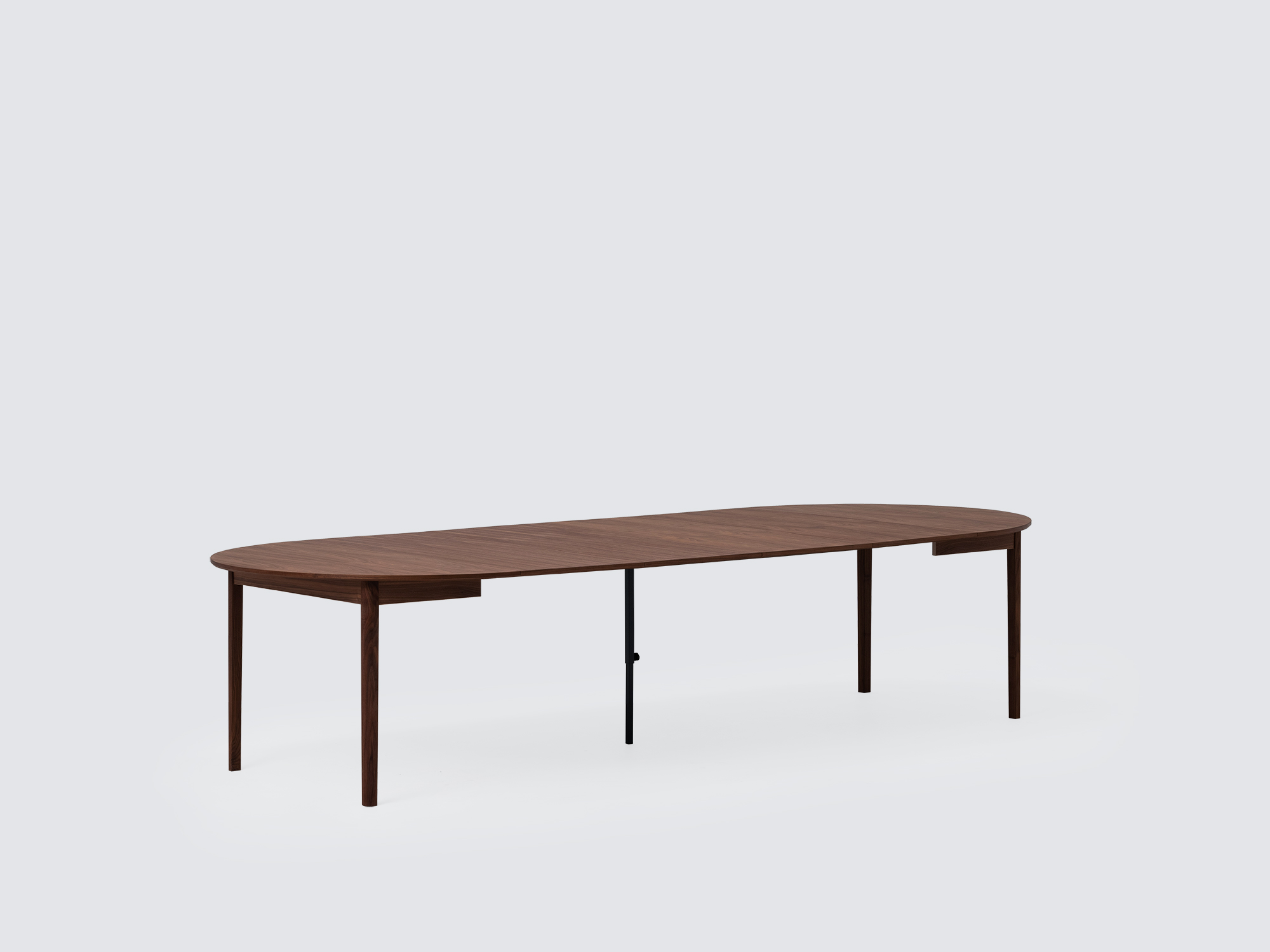 Angled view of the large expanded Ease Expandable Dining Table in walnut