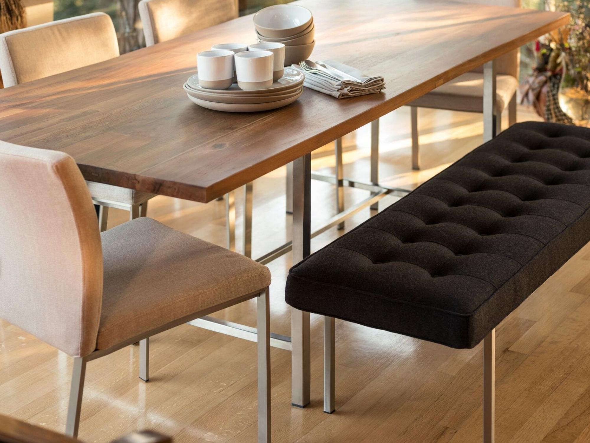 Black fabric bench at oak table in modern dining room