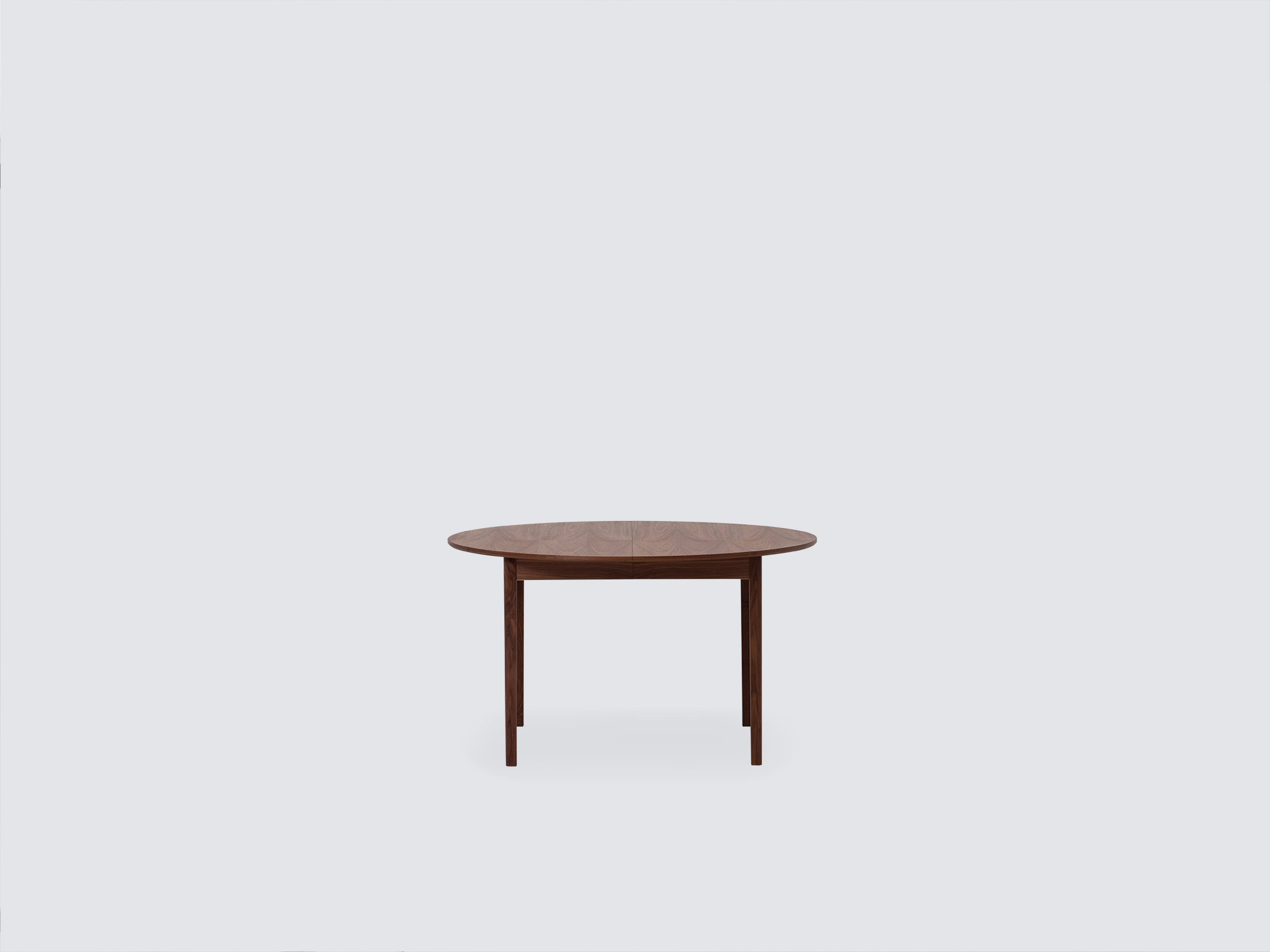 Front view of the small Ease Expandable Dining Table in walnut