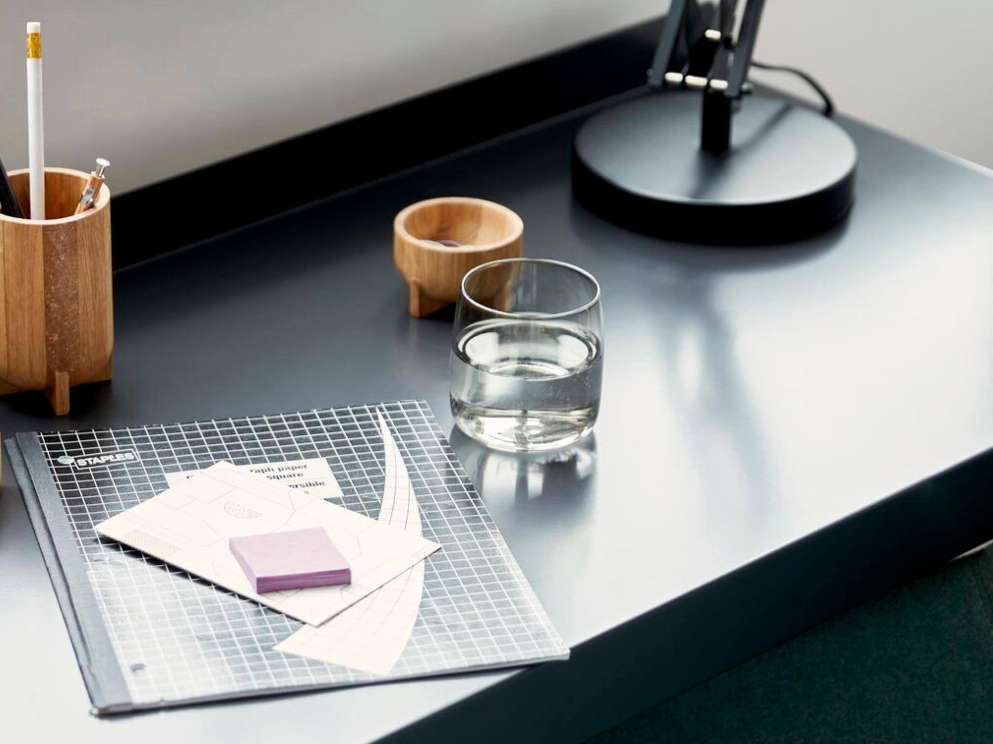 Glass tumbler on black desk in modern home workspace