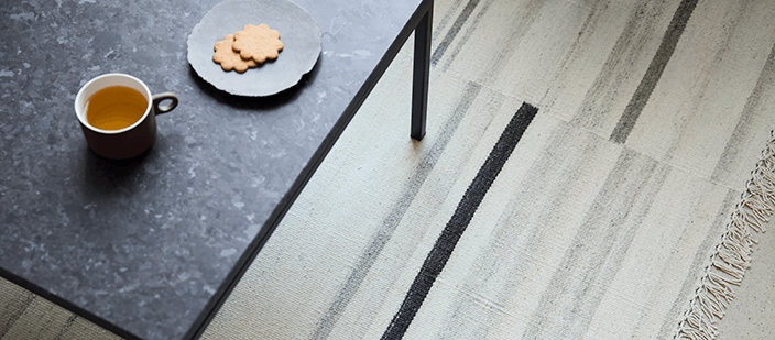 Beige and black pattern rug under black coffee table