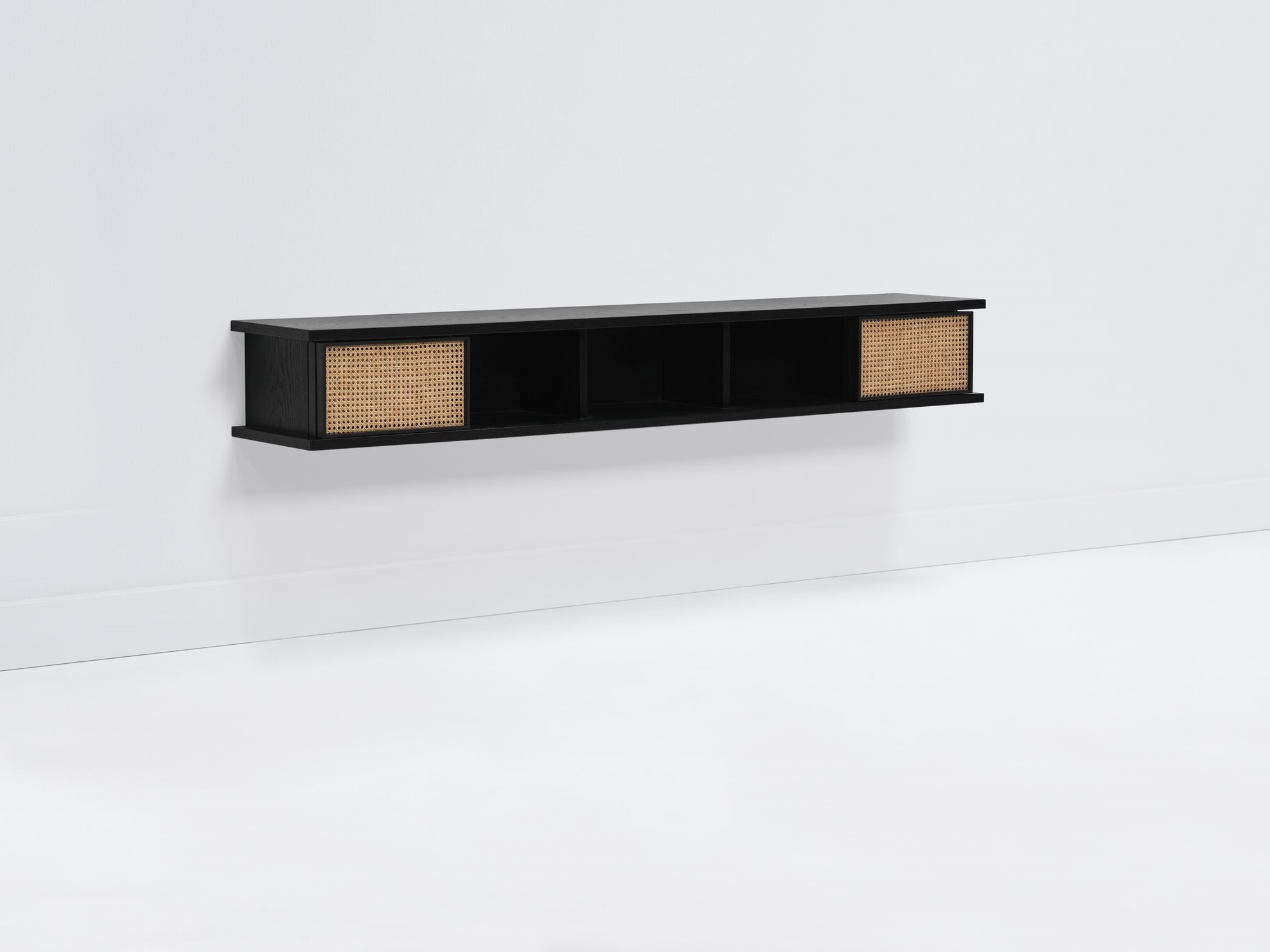 Long black floating shelf with natural cane doors open front angle view