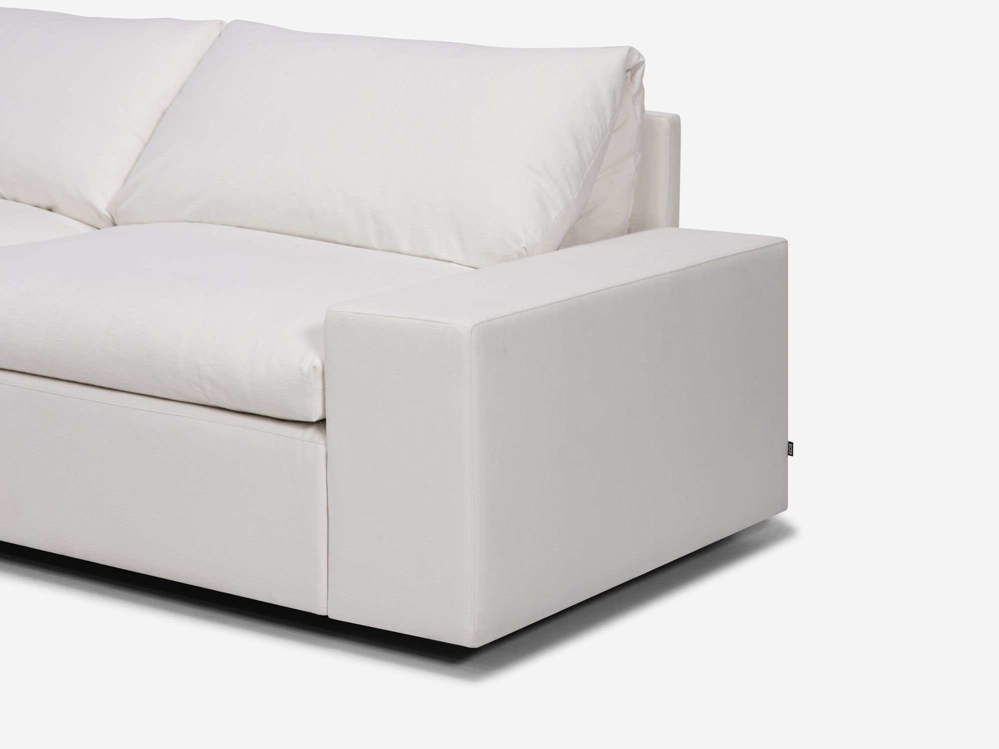 White sectional sofa with left hand chaise and wide arms seat detail view