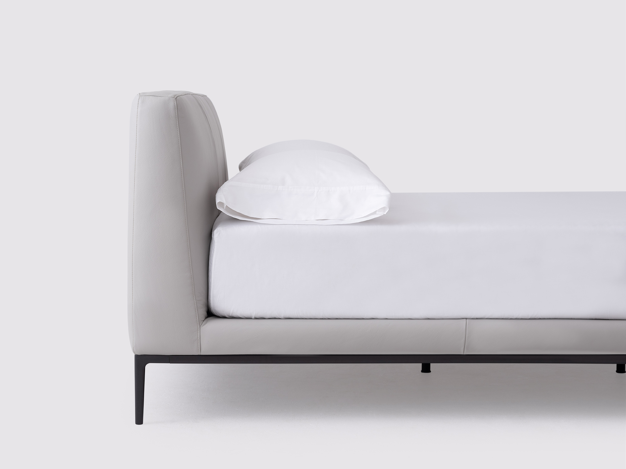 Detail view of the Oma modern upholstered bed in grey leather