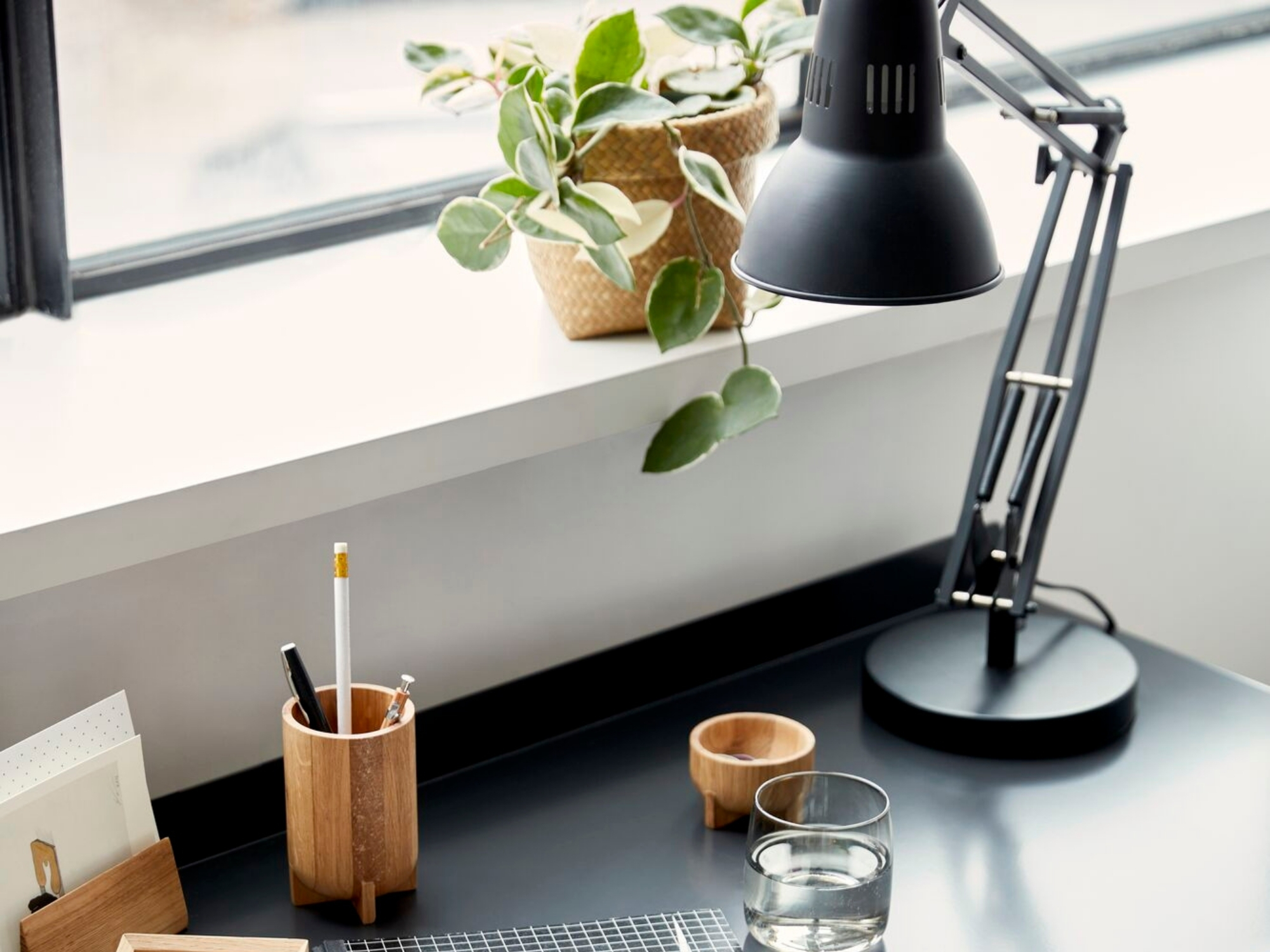 Black metal desk lamp on a black modern desk with chair