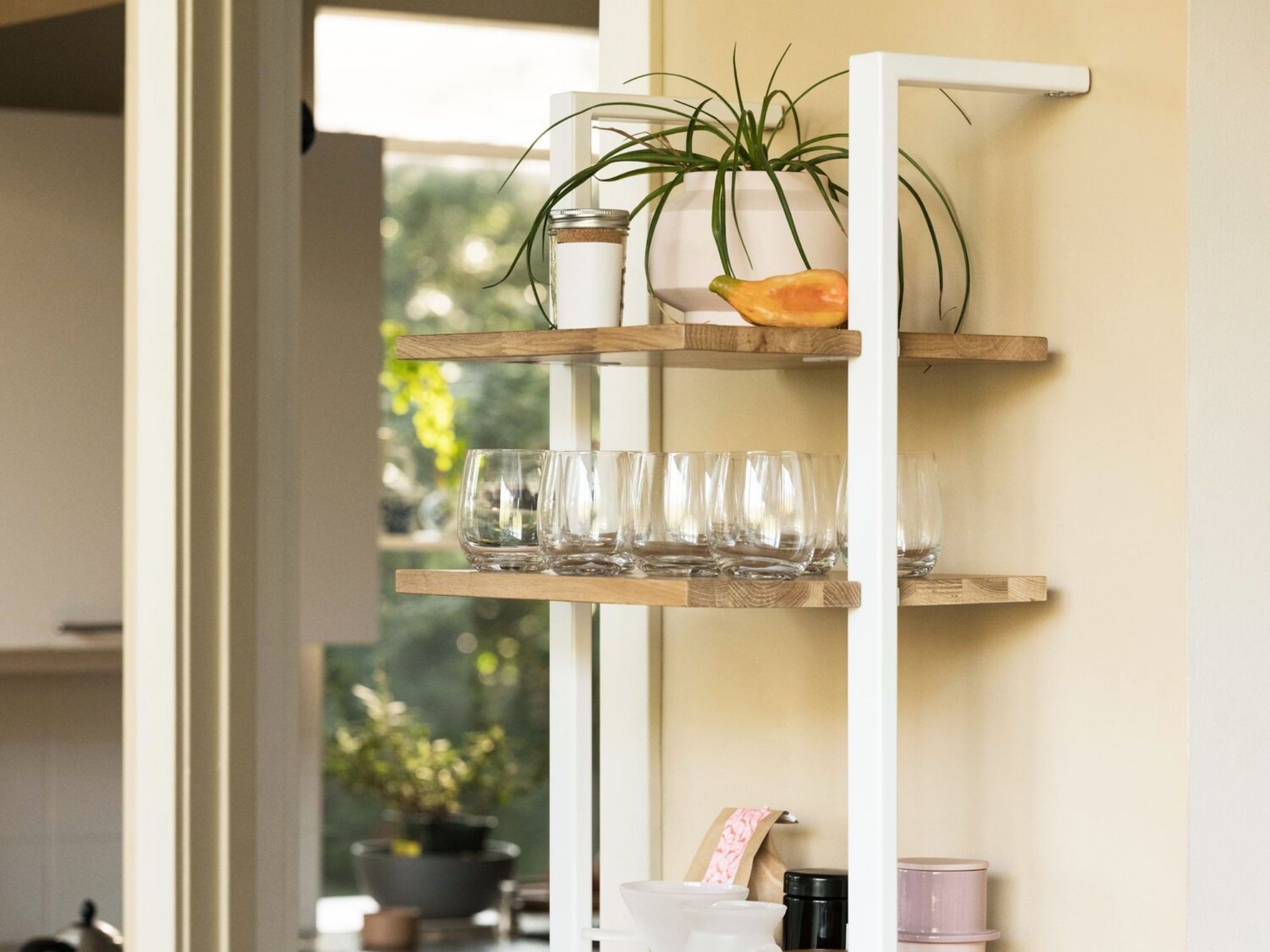 Rows of clear tumbler glasses on open shelving