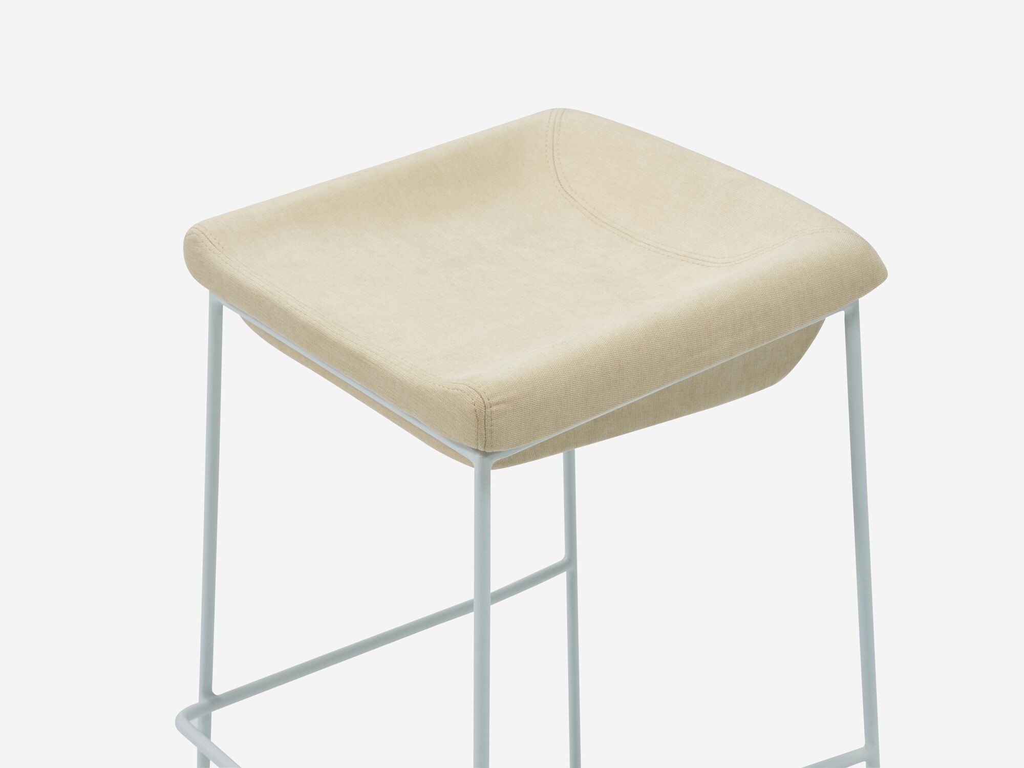 Counter stool with beige seat and white legs detail view