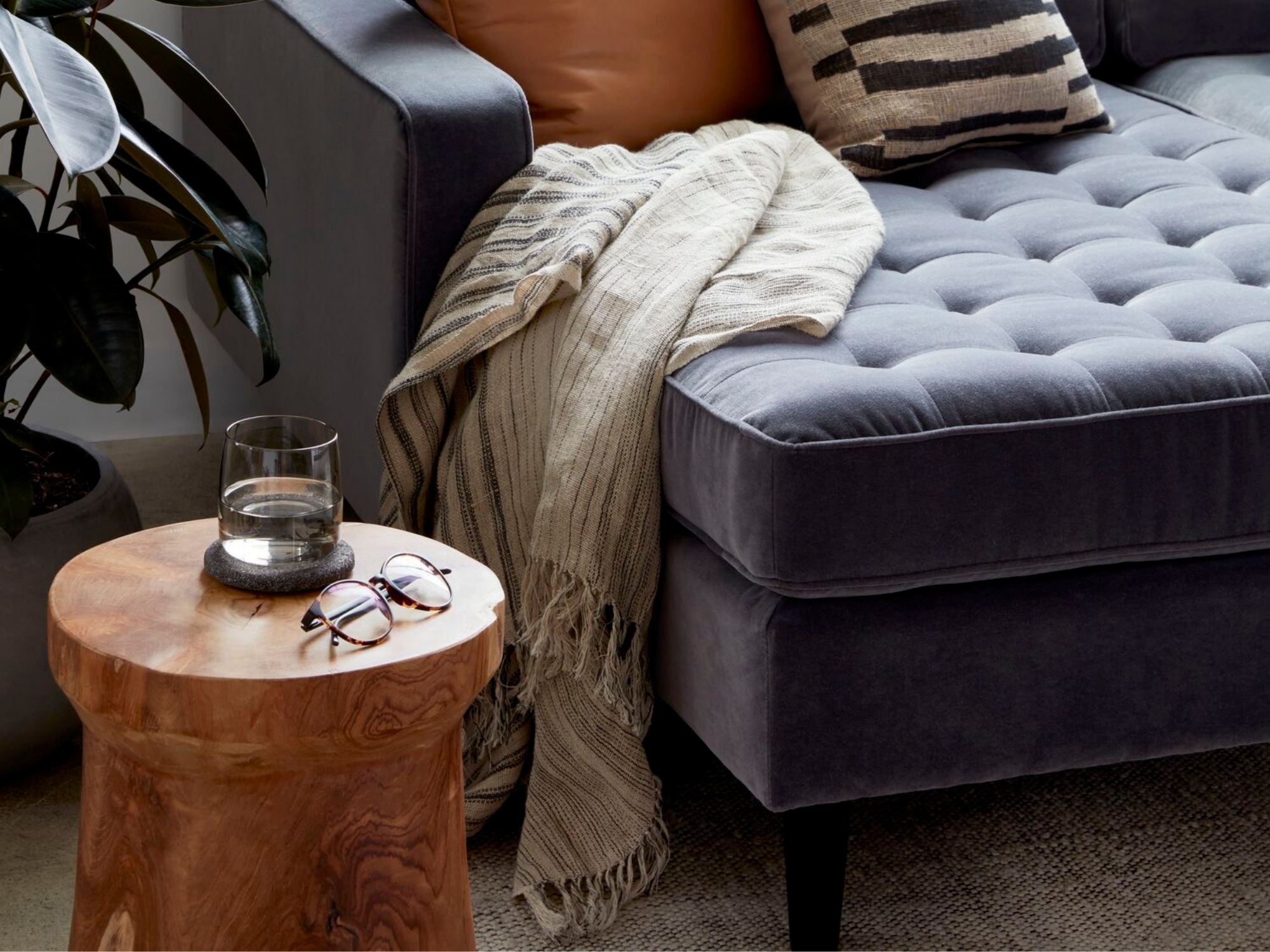 Teak wood stool beside a mid century modern inspired sofa