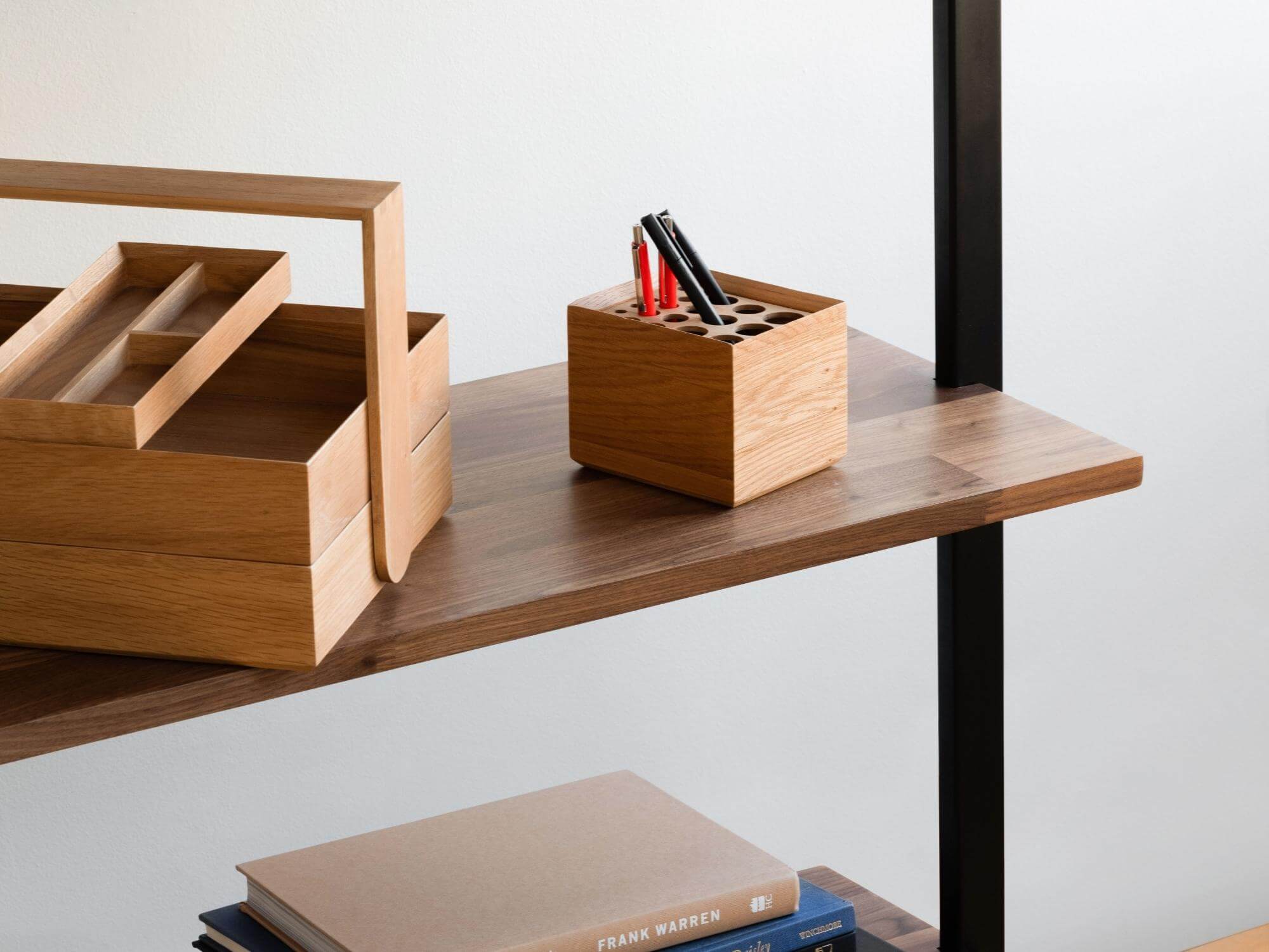 Oak pencil box with matching caddy on walnut shelf of open bookcase