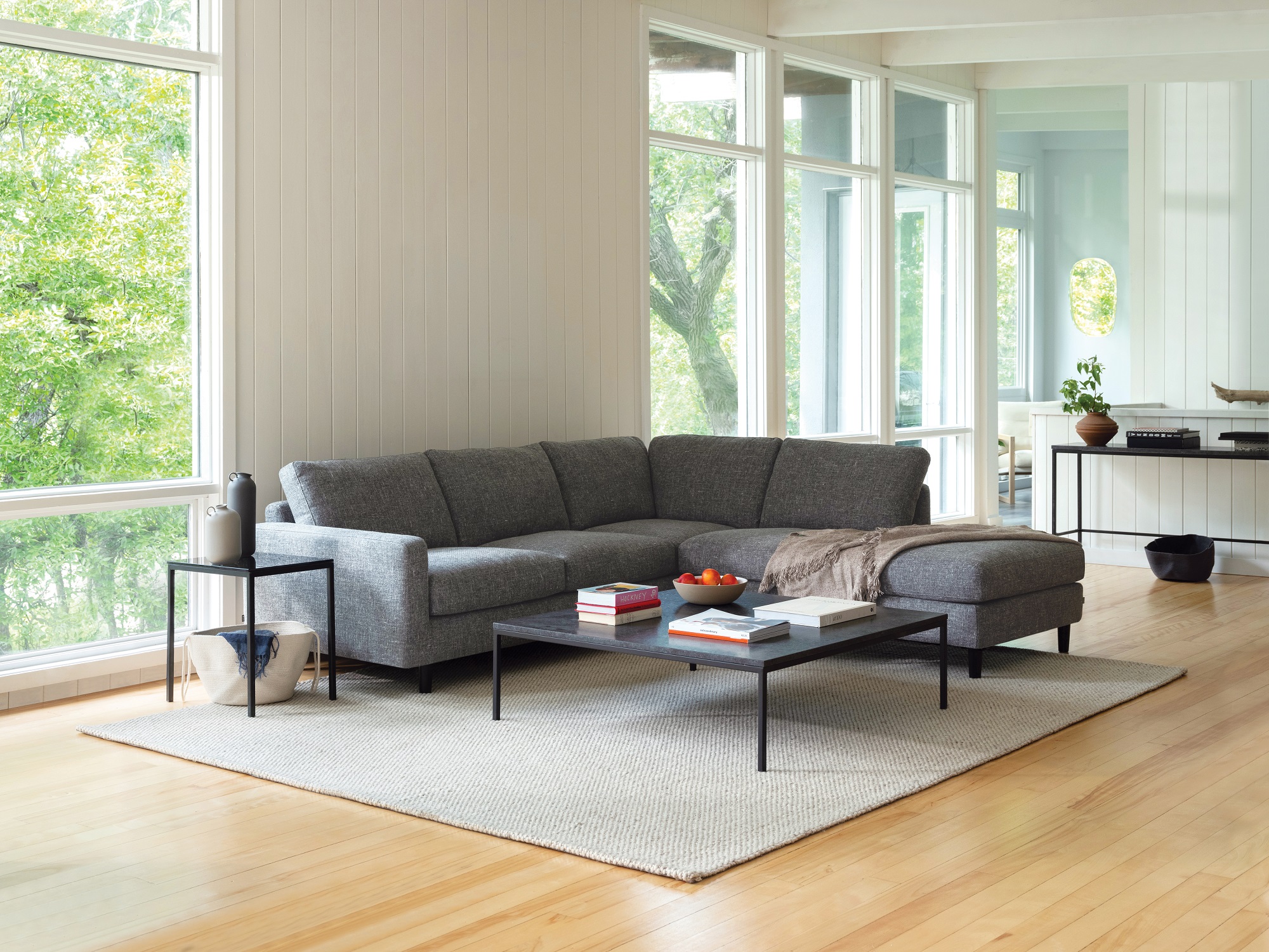 Black marble end table and matching coffee table with grey sectional in large living room