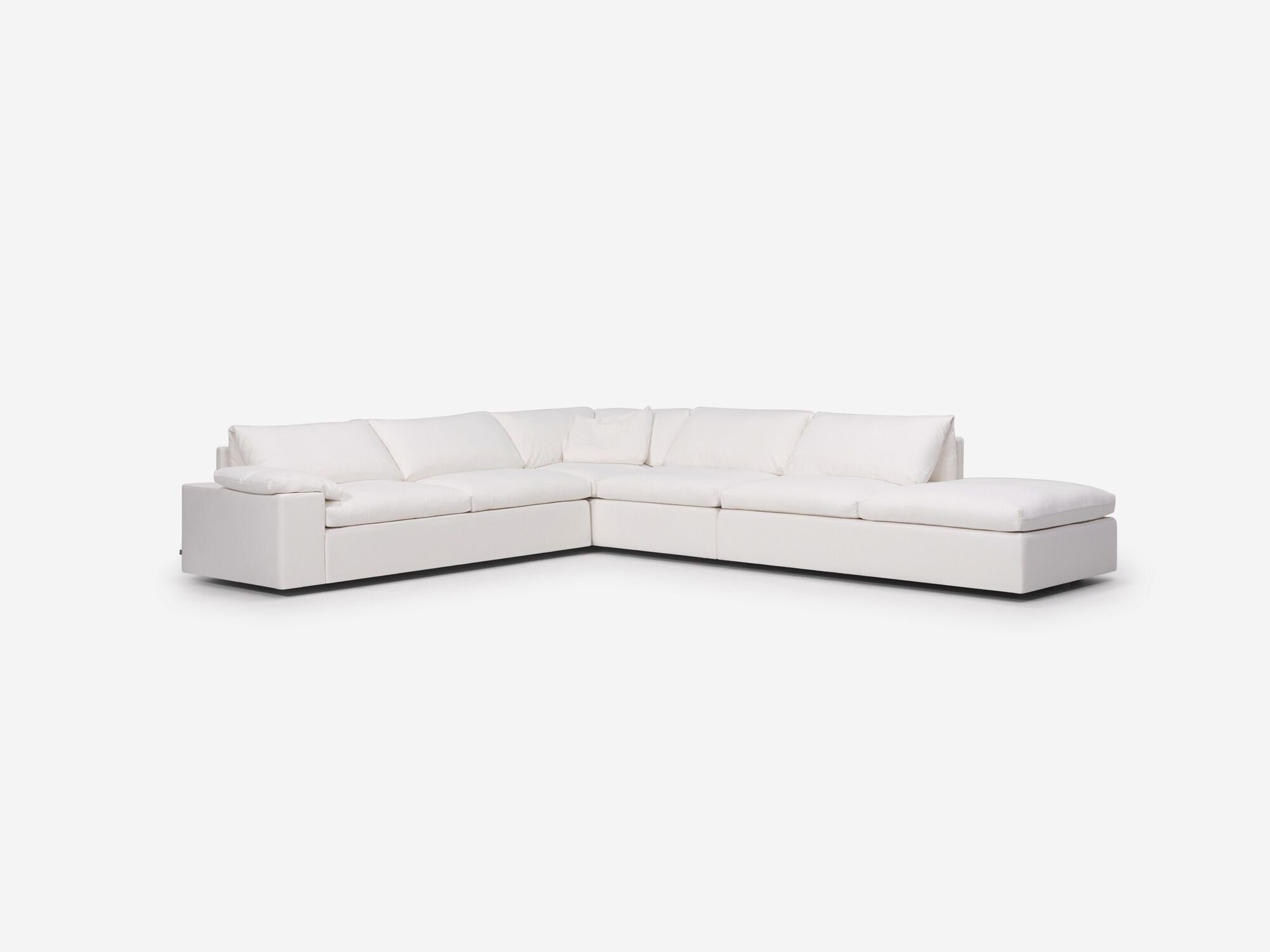 Left angle view of white sectional sofa with right hand chaise, pillow and wide arms