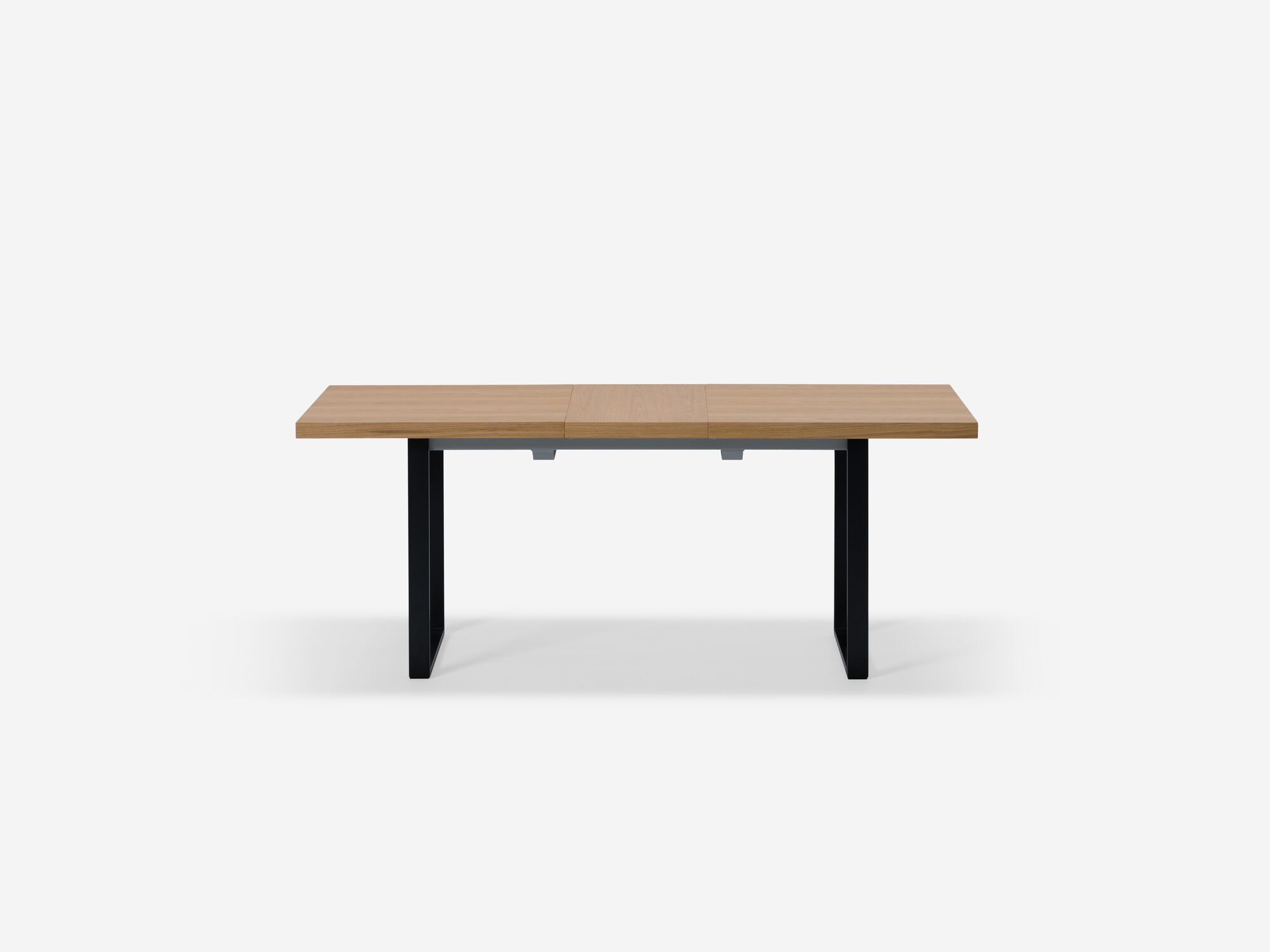 Side view of expandable dining table with black legs and oak top with one leaf