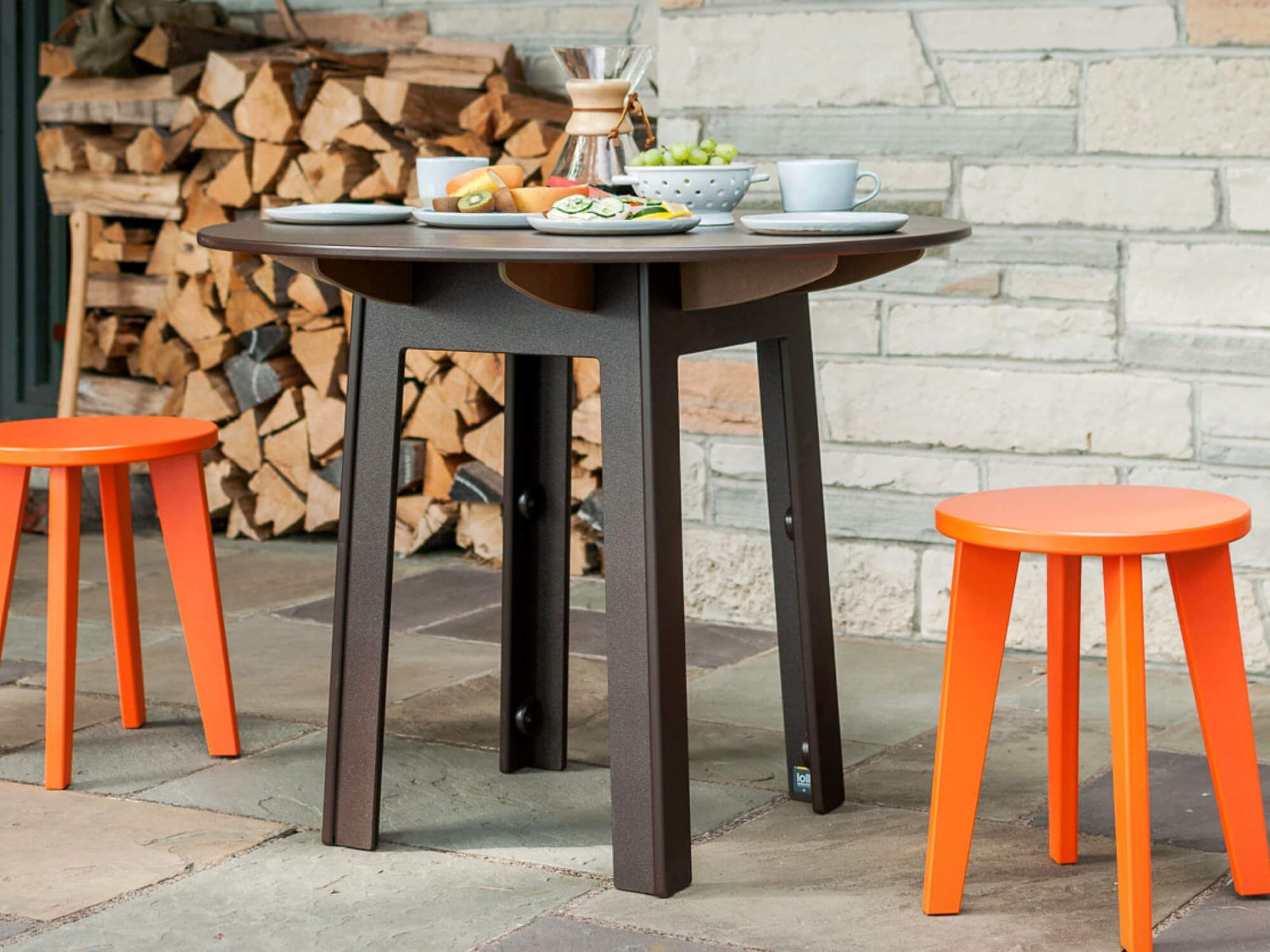 Two orange stools with black outdoor dinette table