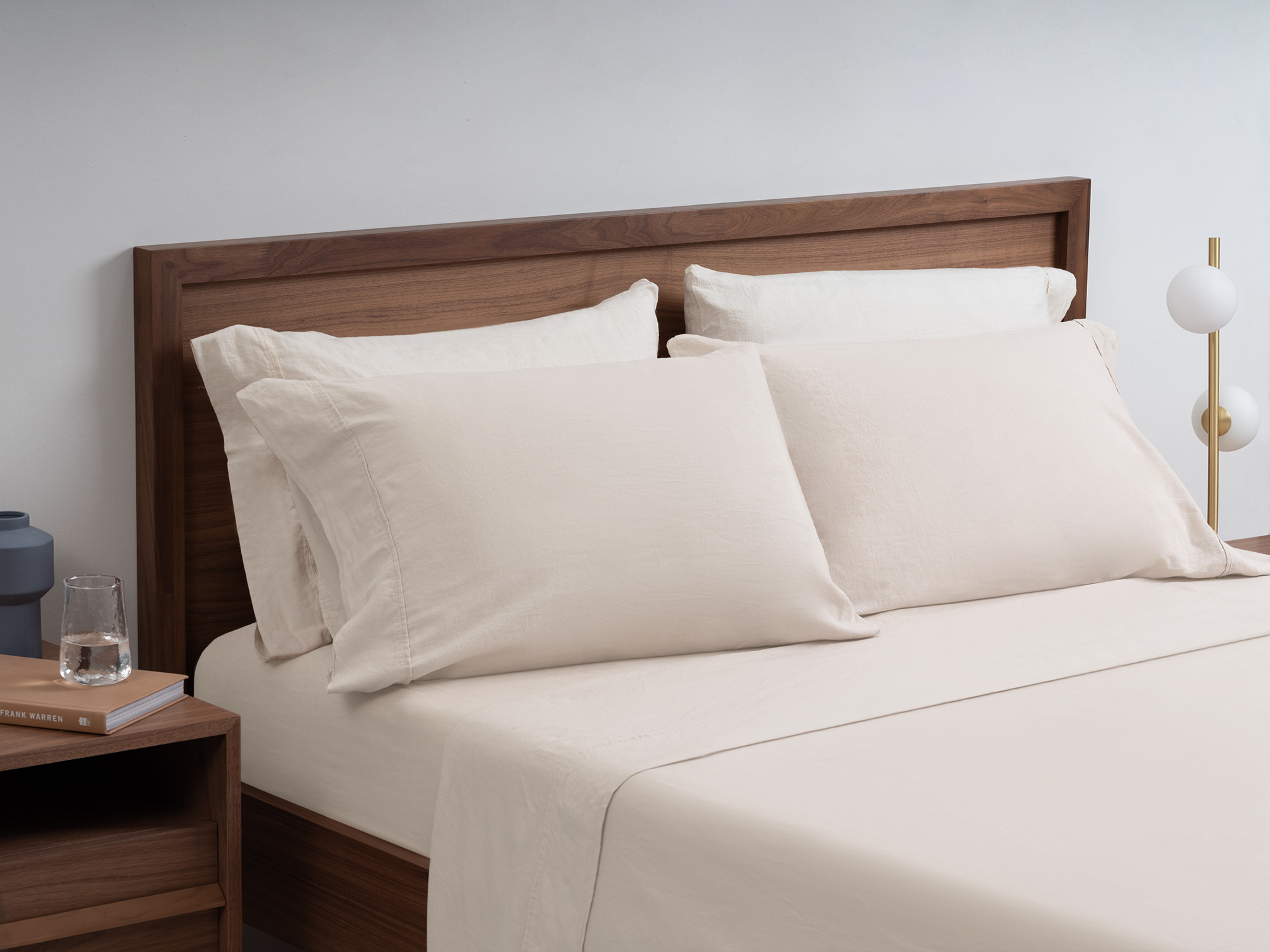 Linen cotton sheets in cream on a walnut bed frame