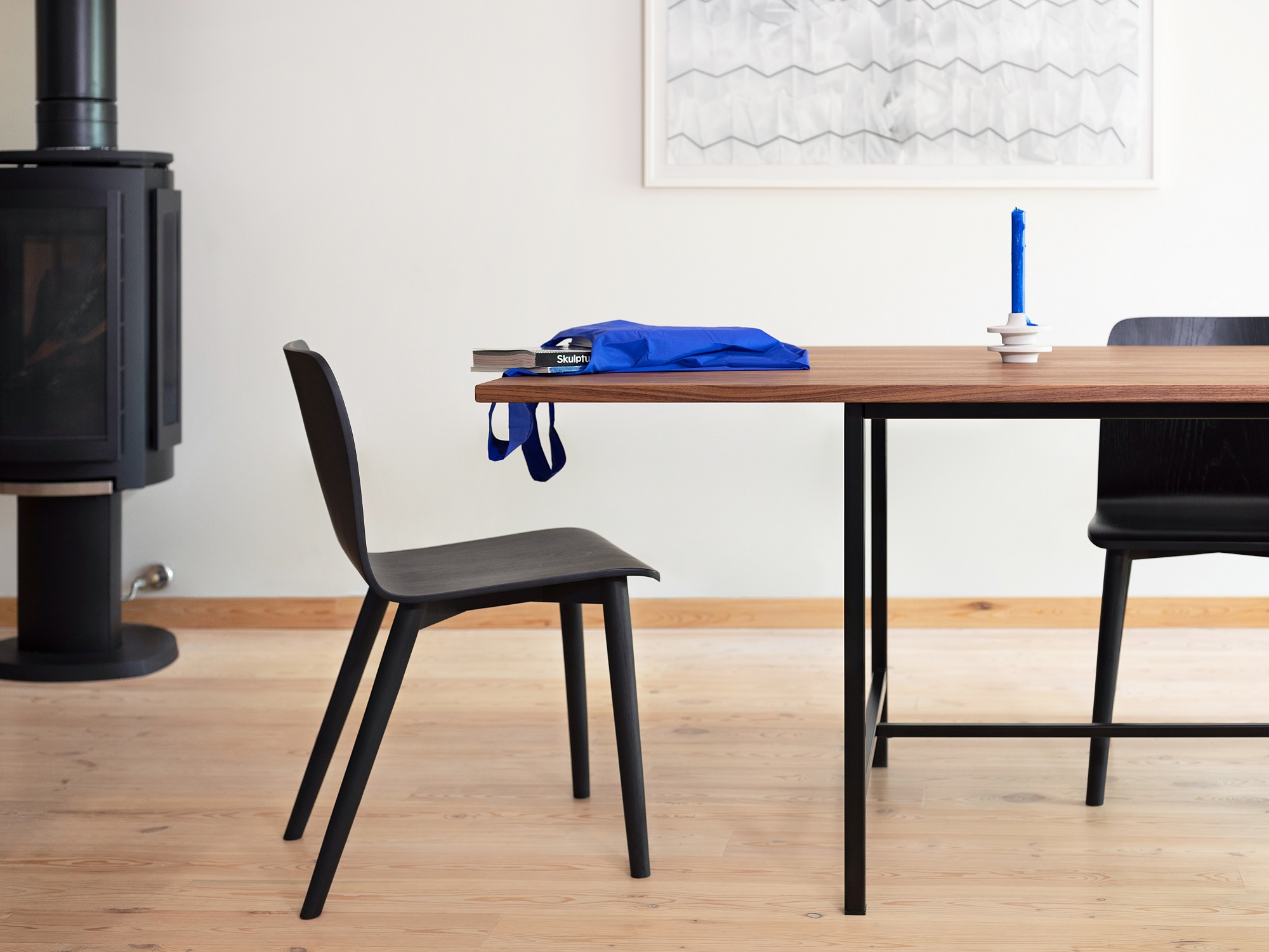 Custom dining table with walnut top with black dining chairs in small living space