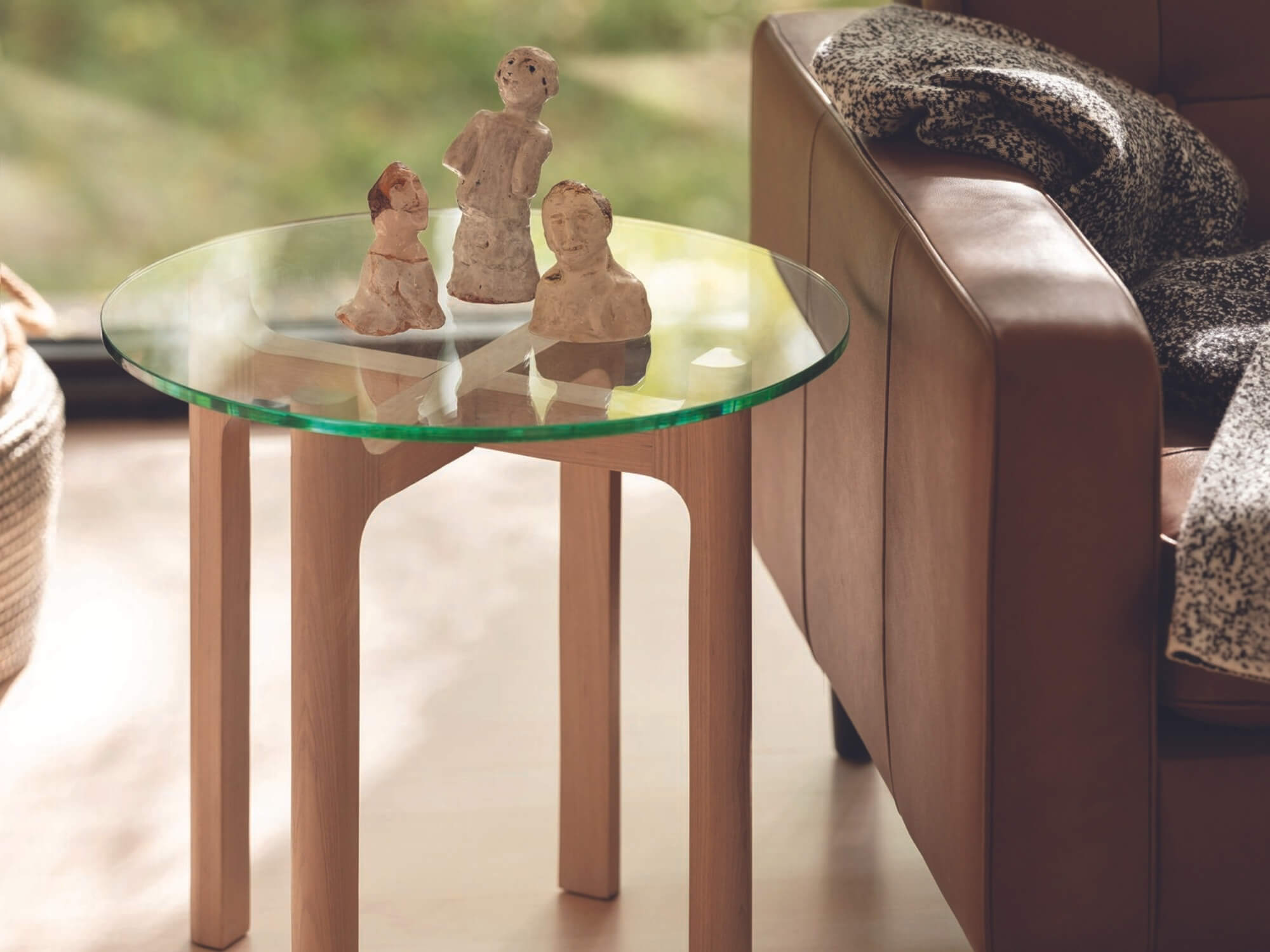 Modern glass top end table next to modern sofa