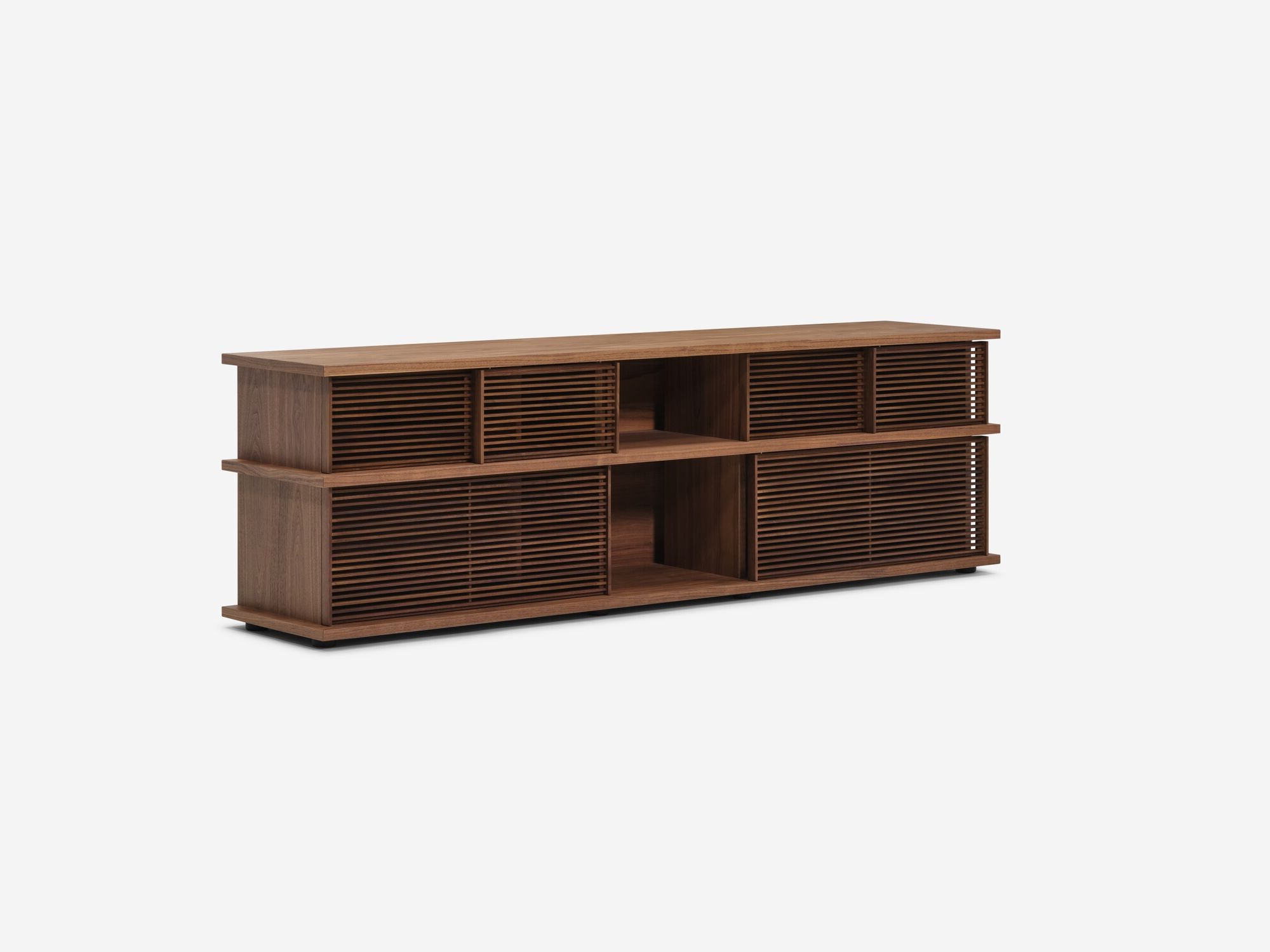 Angled view of the Plank tall modern media console in walnut with closed drawers and slats