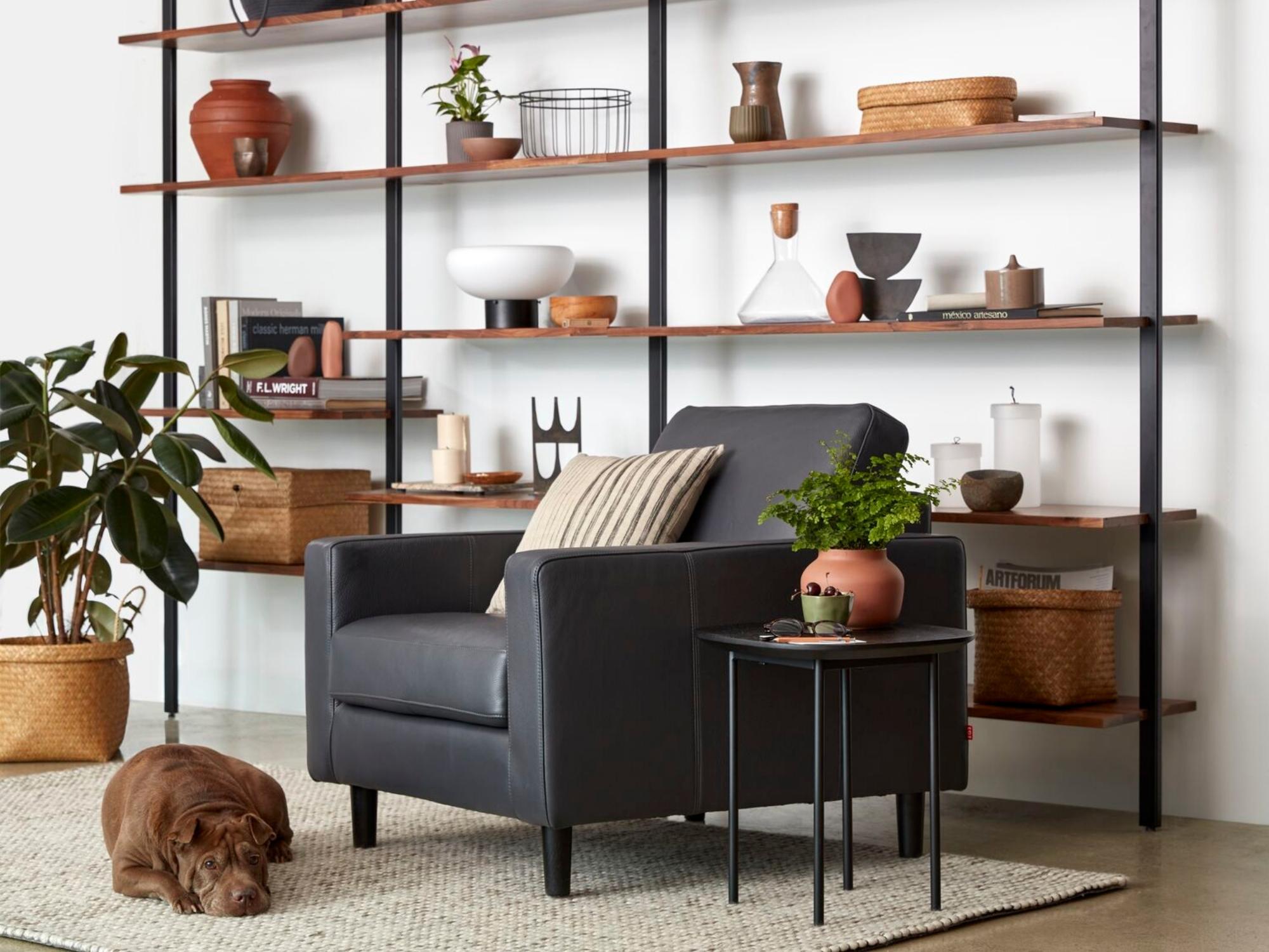 Terracotta plant pot on open shelf bookcase beside leather chair