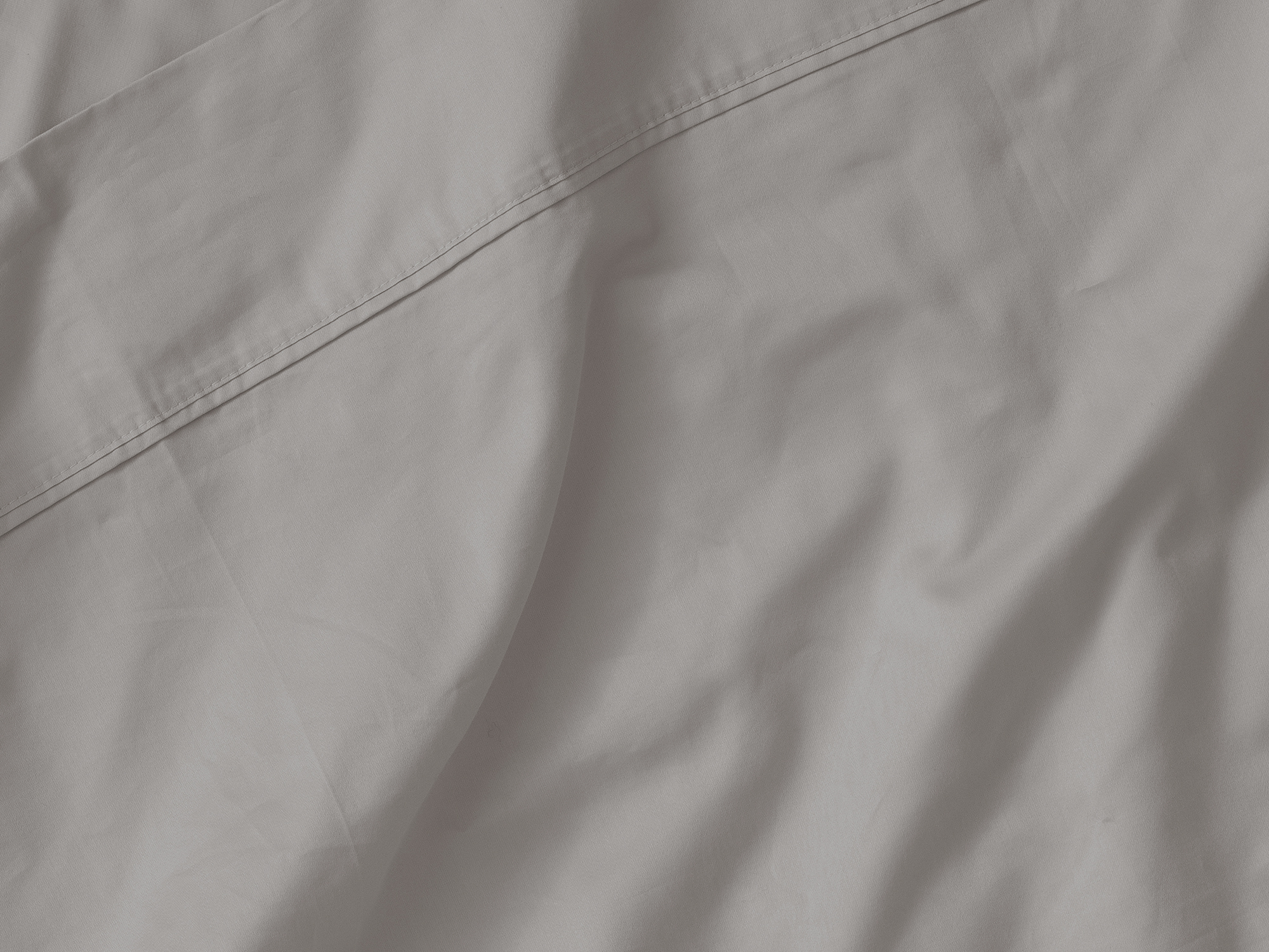 Detail view of organic cotton bed sheets in grey