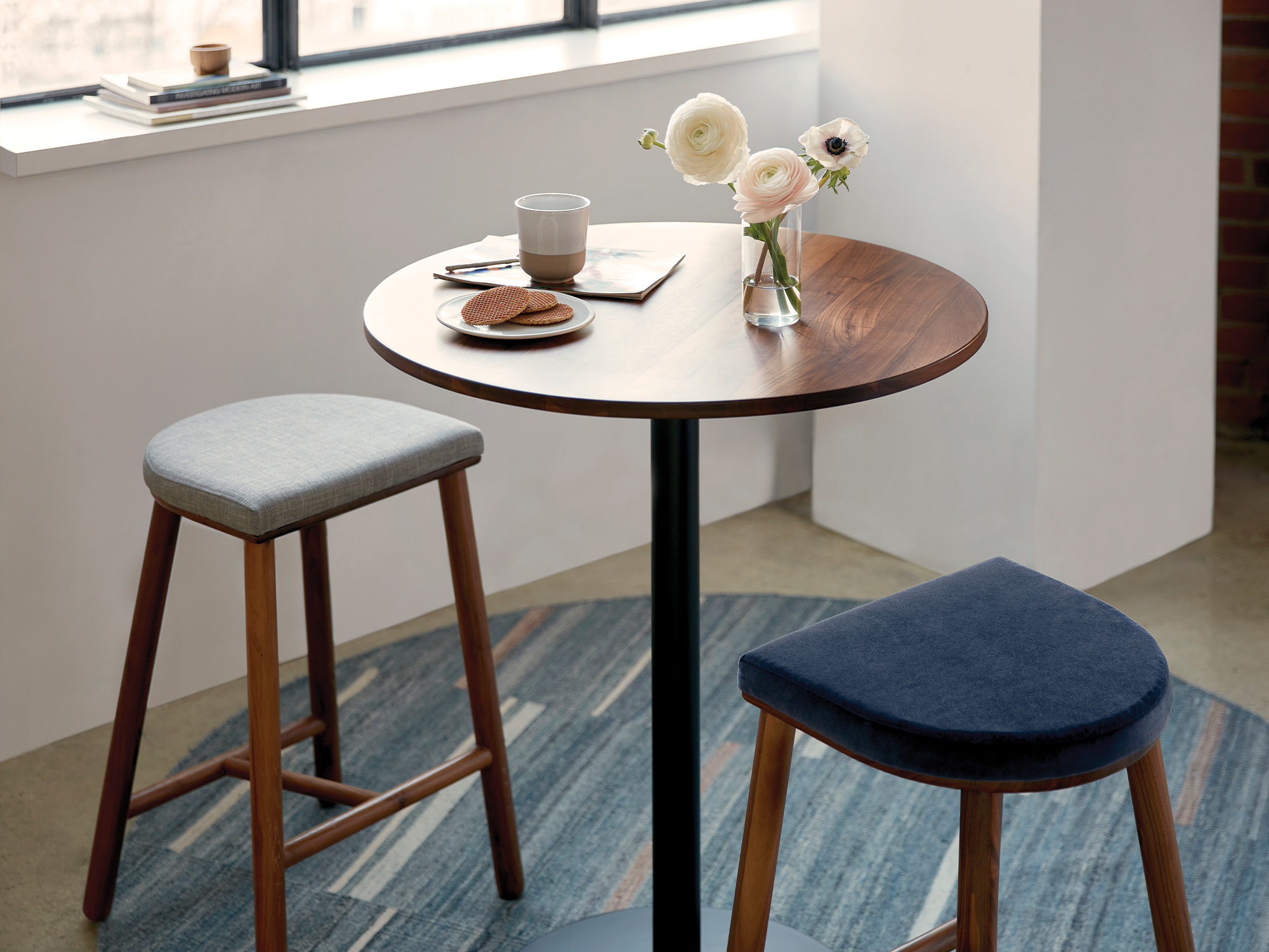 Round counter height table with walnut top and counter stools around it